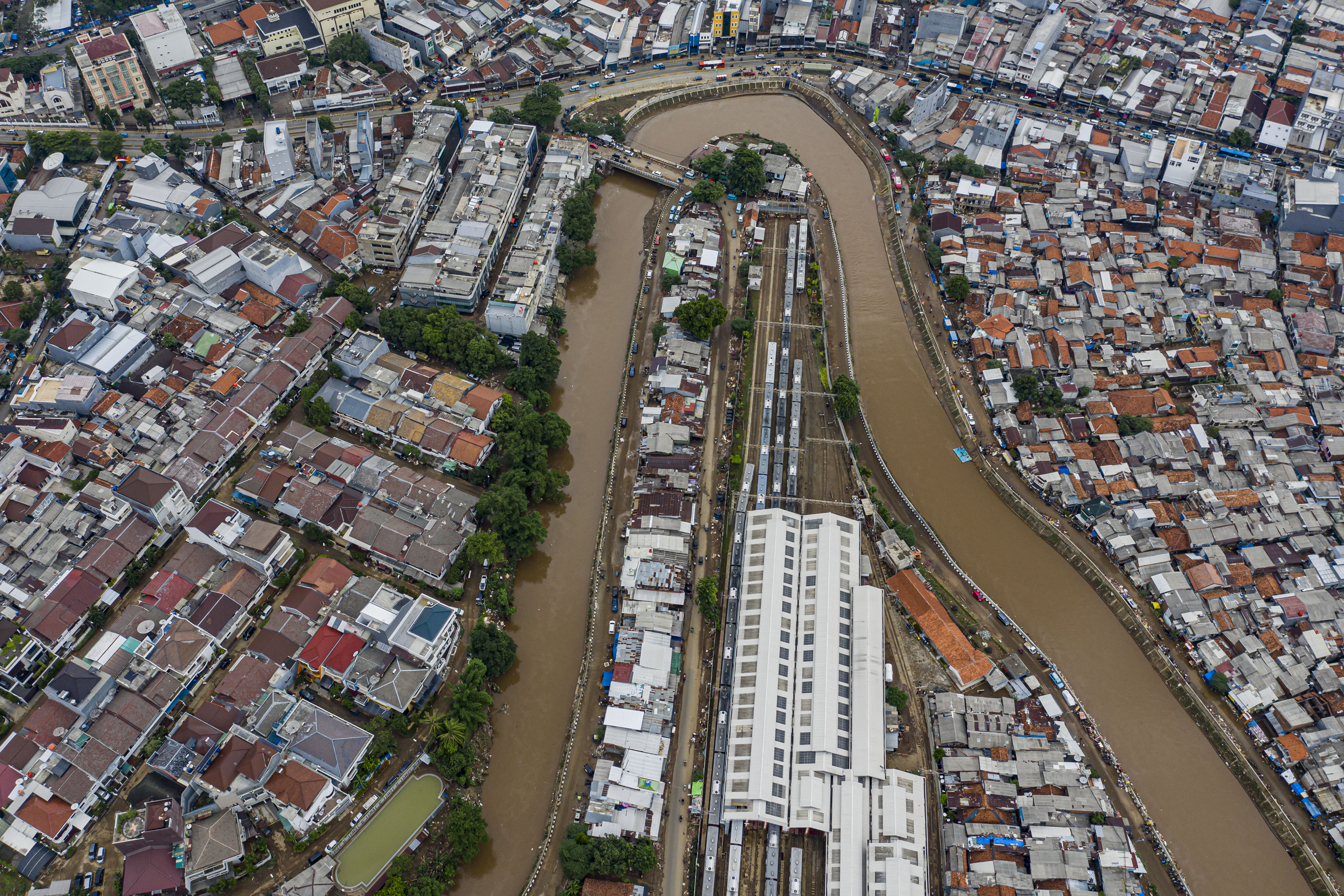 Foto udara suasana wilayah bantaran sungai Ciliwung yang belum dinormalisasi (kiri) di wilayah Bukit Duri, Jakarta