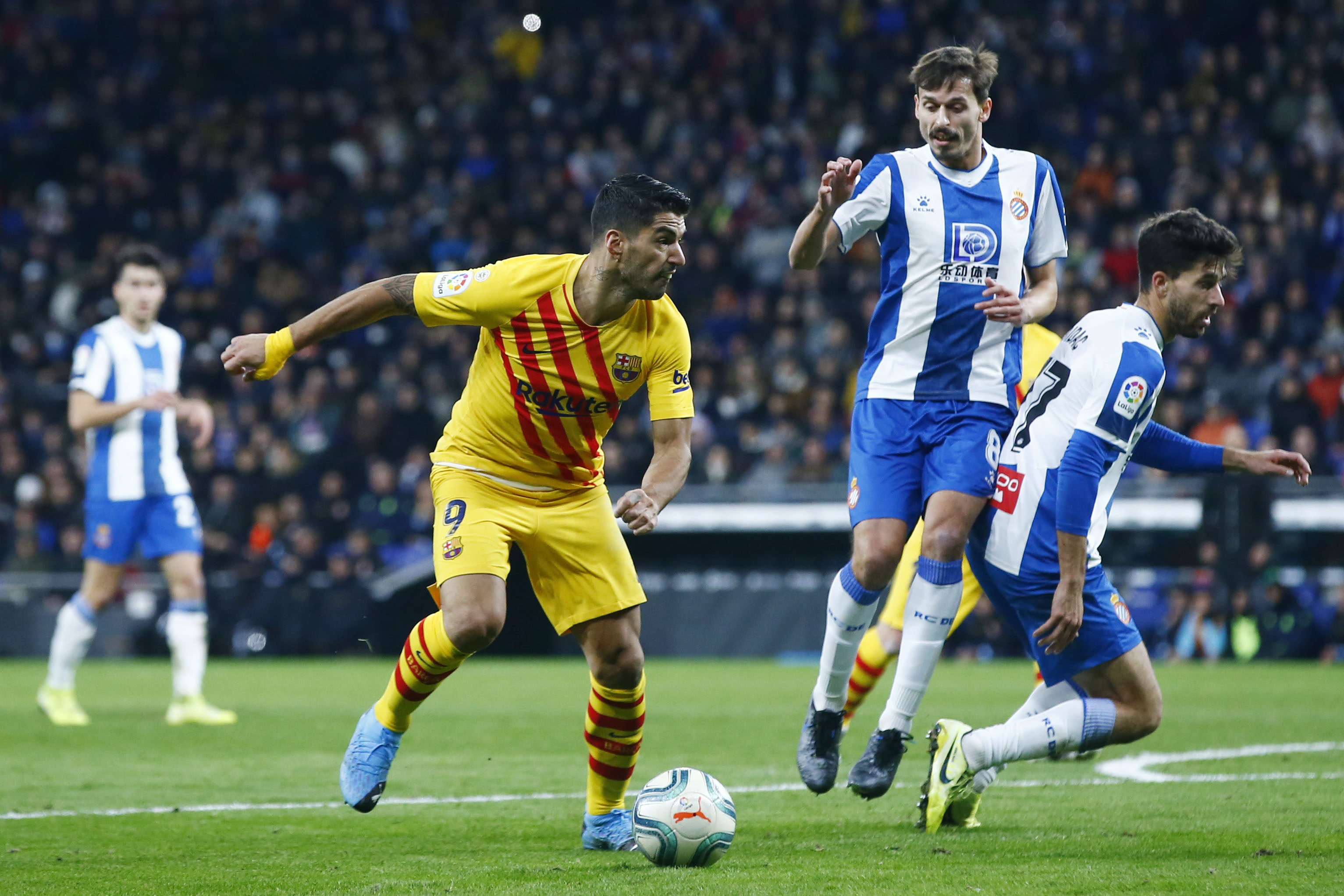Luis Suarez bersaing dengan gelandang Espanyol Ander Iturraspe (2R) dan bek Spanyol Espanyol Didac Vila (kanan) selama pertandingan  