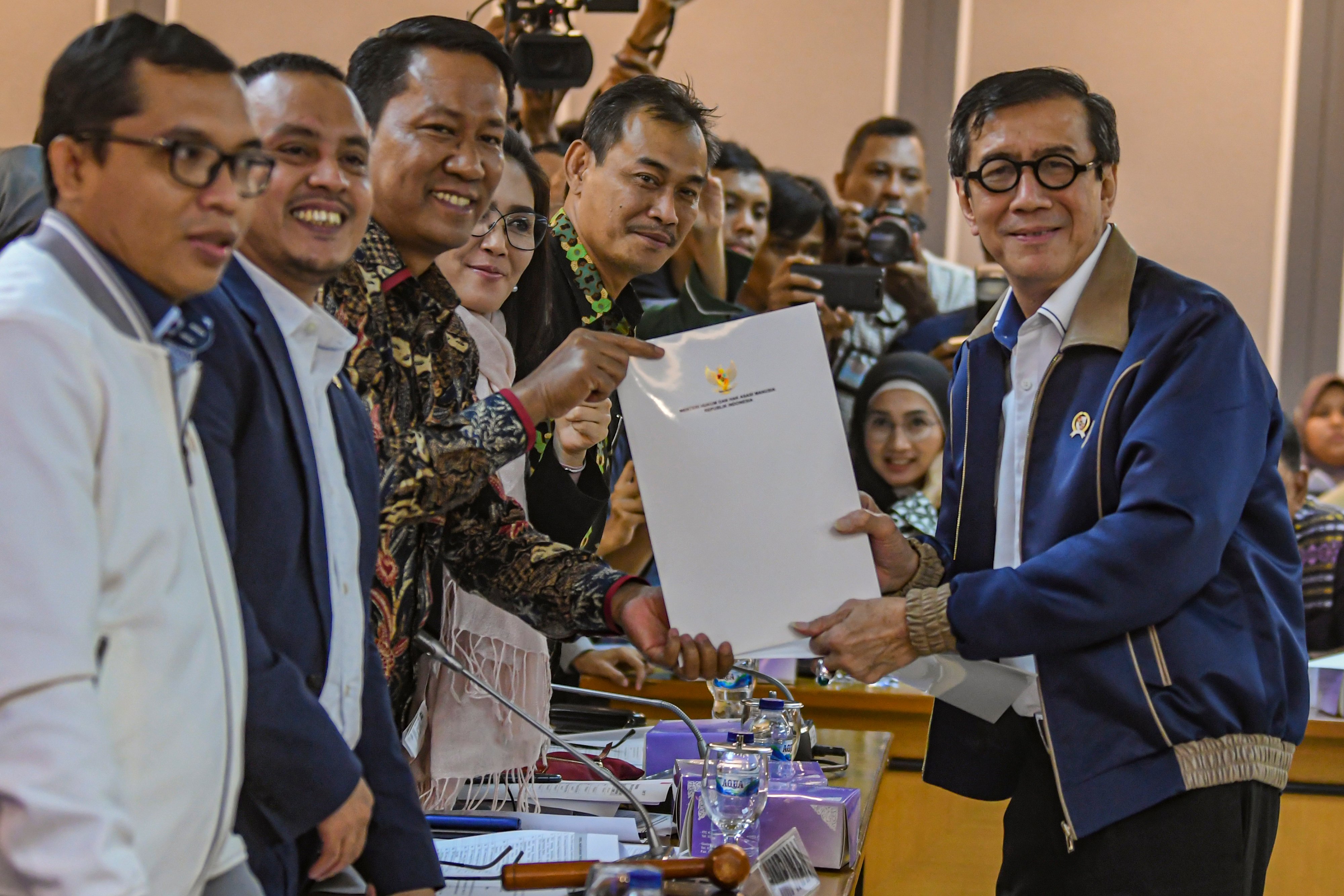 Menteri Hukum dan HAM Yasonna H Laoly (kanan) menyerahkan dokumen kepada Ketua Badan Legislasi (Baleg) Supratman Andi Agtas.