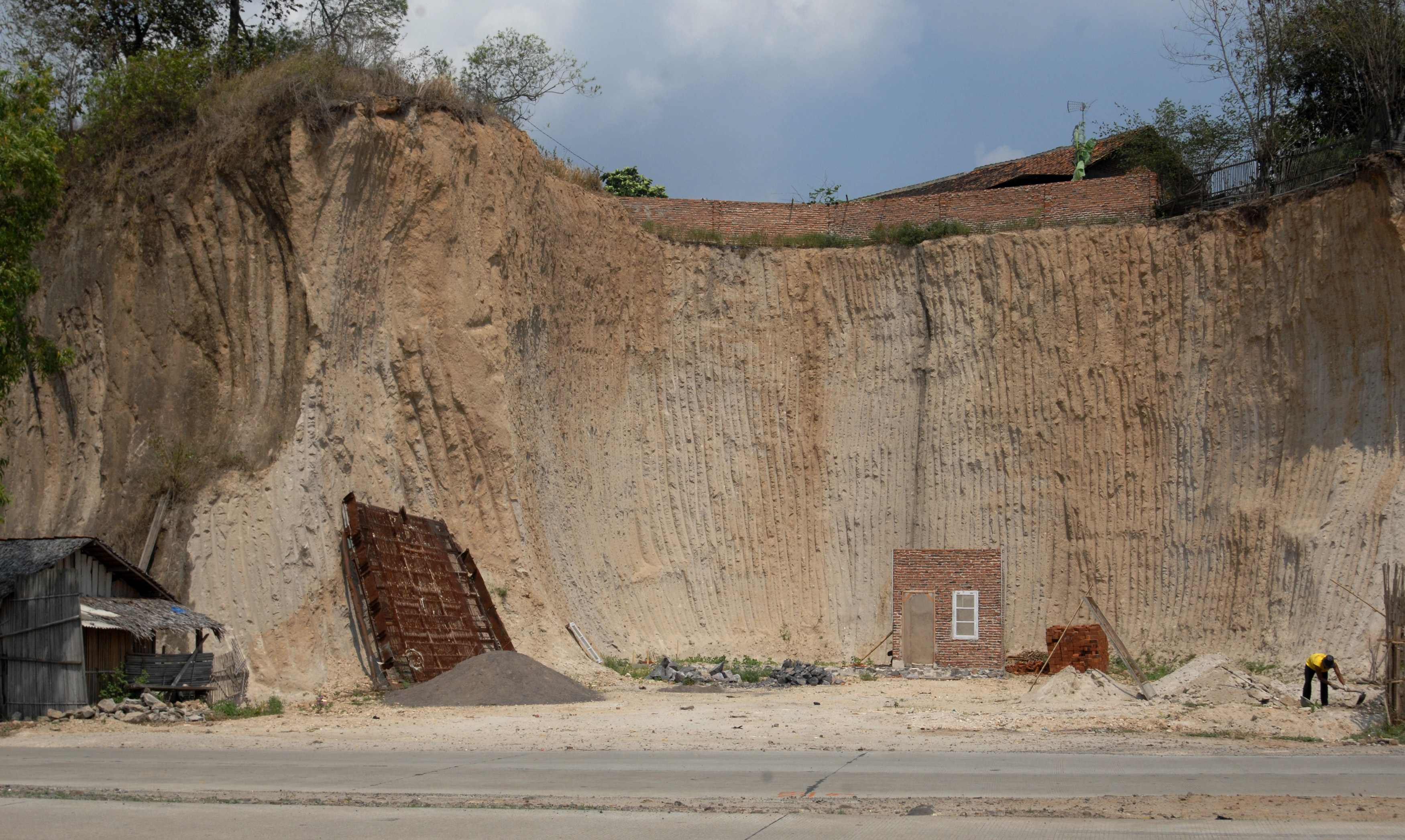 Pekerja mencangkul pasir di tempat bekas galian tambang ilegal di Cirenong, Lebak Denok, Cilegon, Banten.