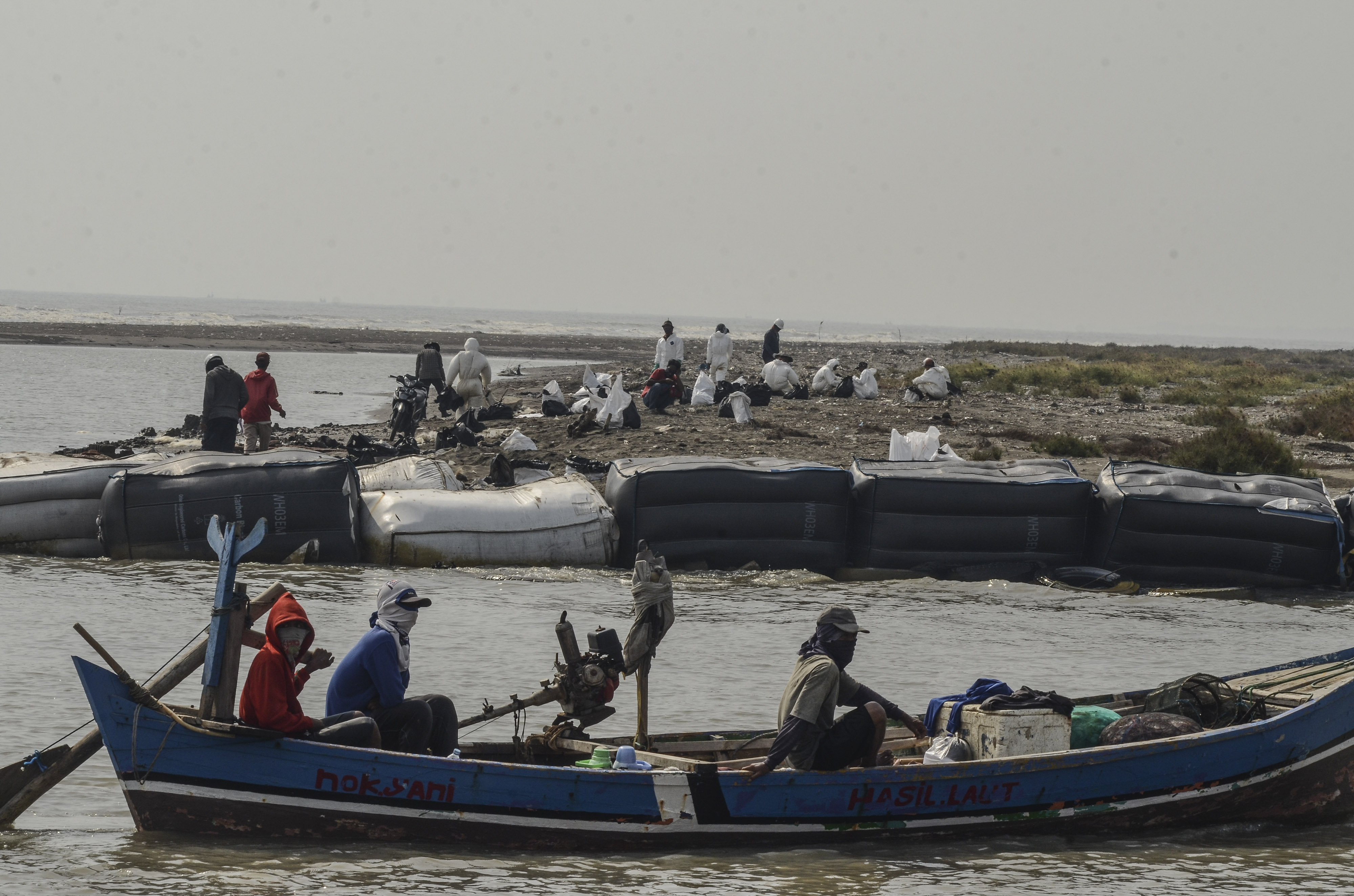 Nelayan melintas di sekitar lokasi terdampak tumpahan minyak dari sumur Pertamina Hulu Energi di Pantai Bungin, Karawang, Jawa Barat.