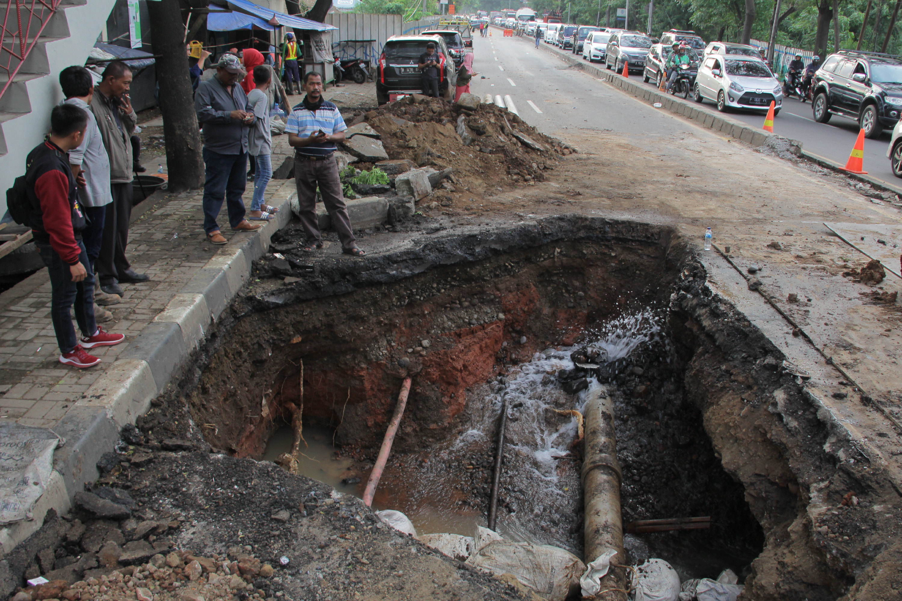 Jalan amblas di bawah Jembatan Penyebrangan Orang (JPO) SDN Inpres Tanah Tinggi Jalan Daan Mogot, Tangerang, Minggu (12/1/2020)