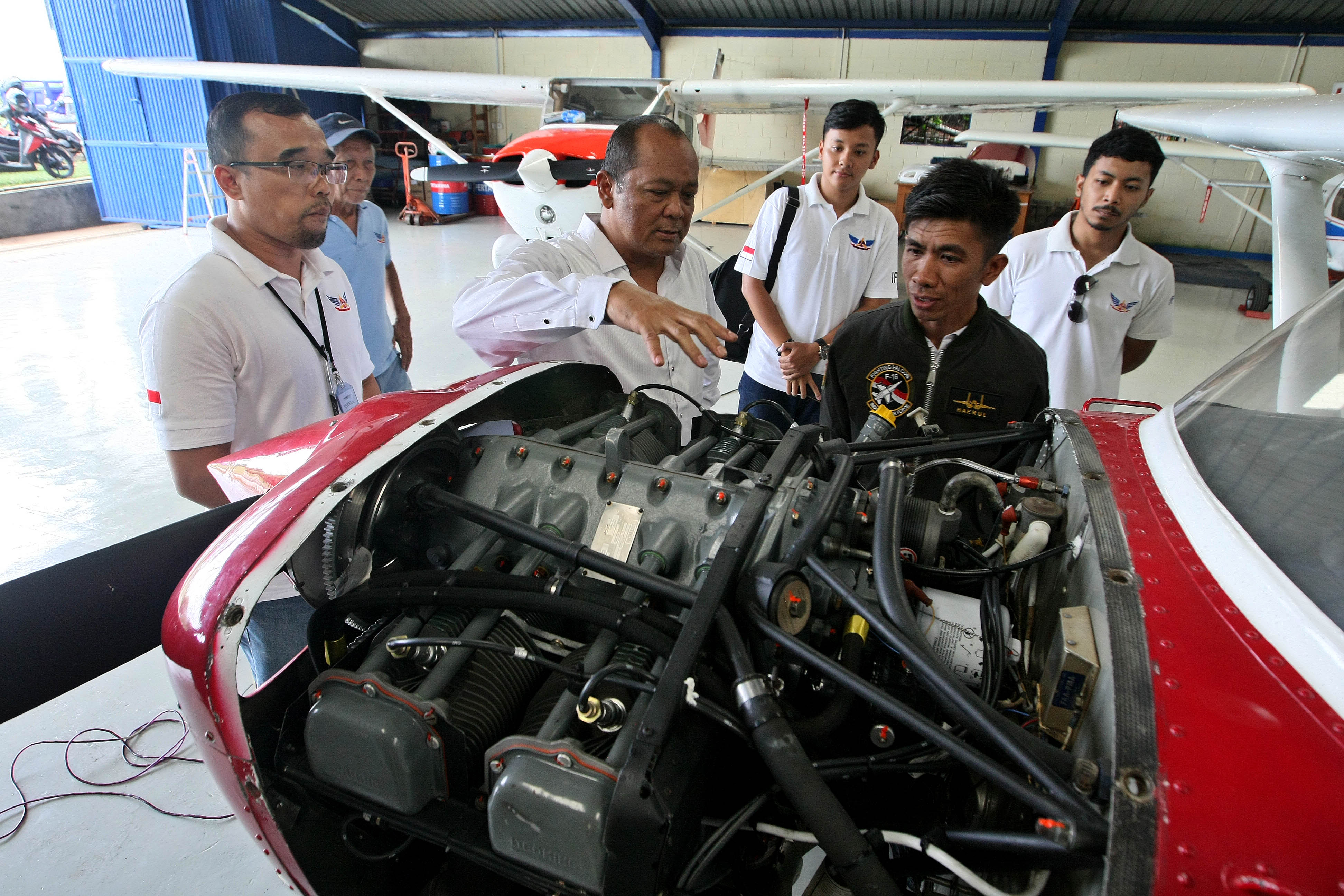Perakit Pesawat Terbang Haerul (kanan) mendapat penjelasan soal mesin pesawat dari Wakil Ketua Indonesia Flying Club (IFC) Untung Medianto