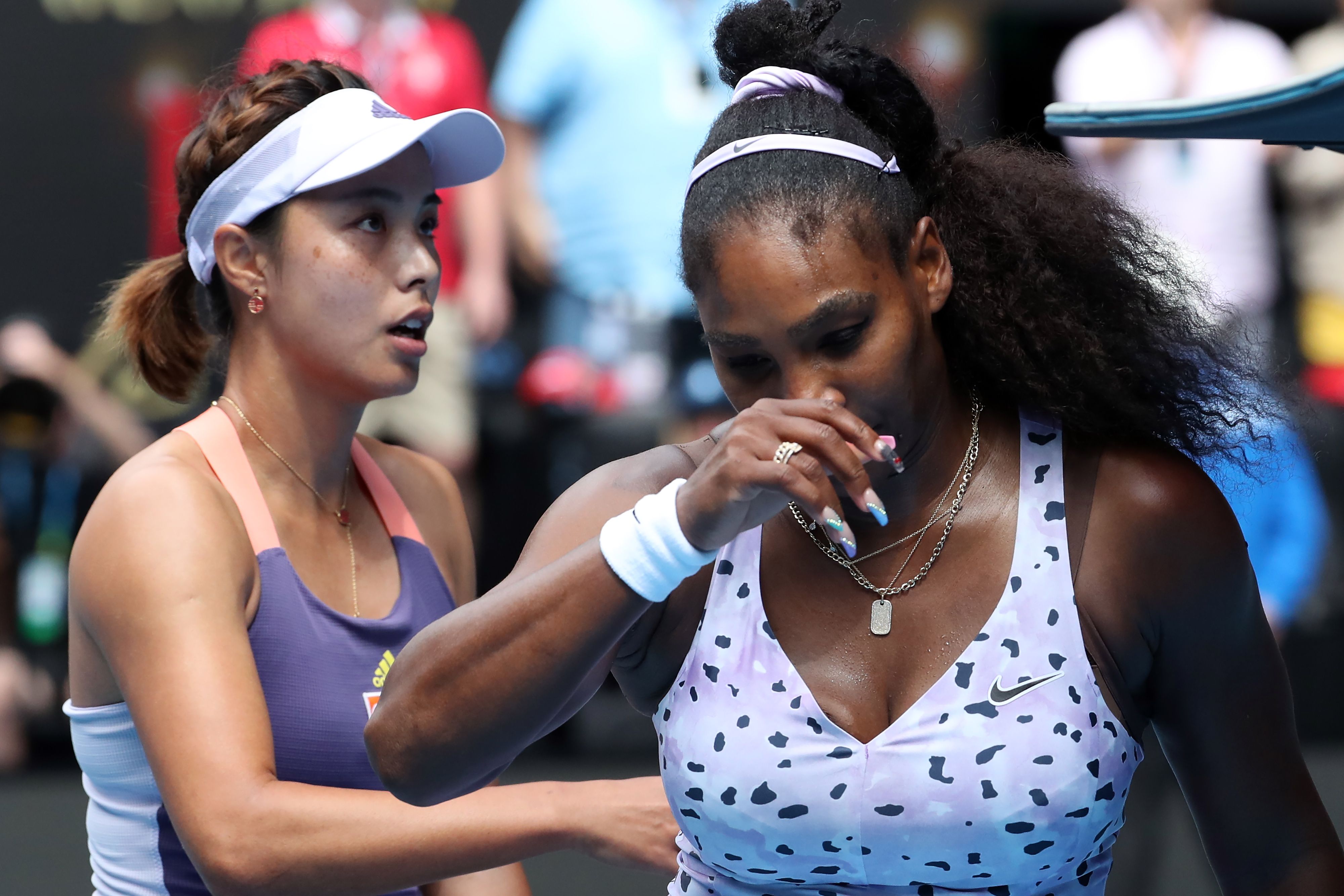 Petenis AS Serena Williams (kanan) meninggalkan lapangan setelah dikalahkan Wang Qiang dari Tiongkok (kiri).