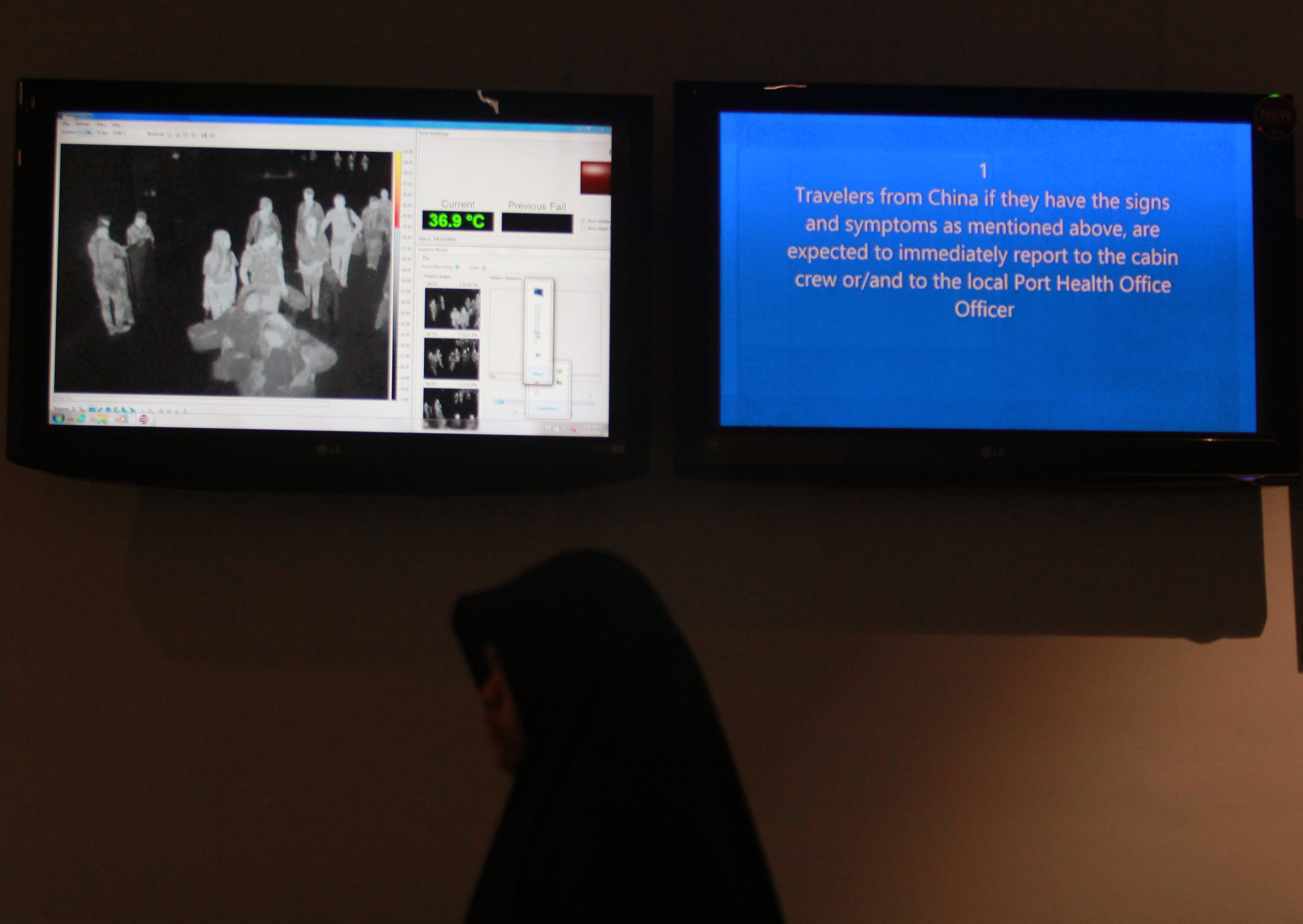 Penumpang melintasi monitor alat thermal scanner atau alat pendeteksi suhu tubuh di Terminal 3 Bandara Soekarno Hatta, Tangerang, Banten.
