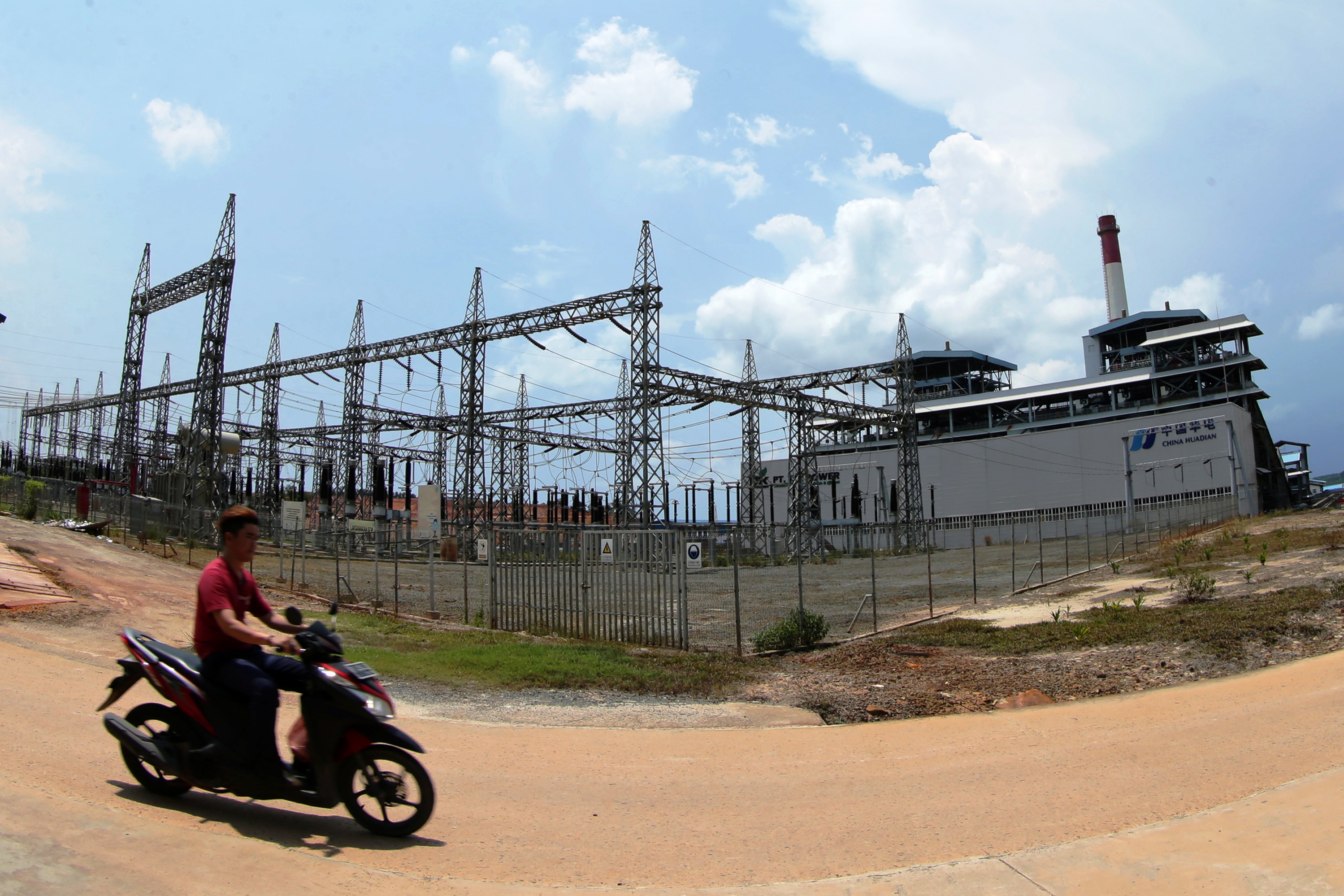 Pekerja melintasi bangunan turbin PLTU Tanjung Kasam, Batam, Kepulauan Riau.