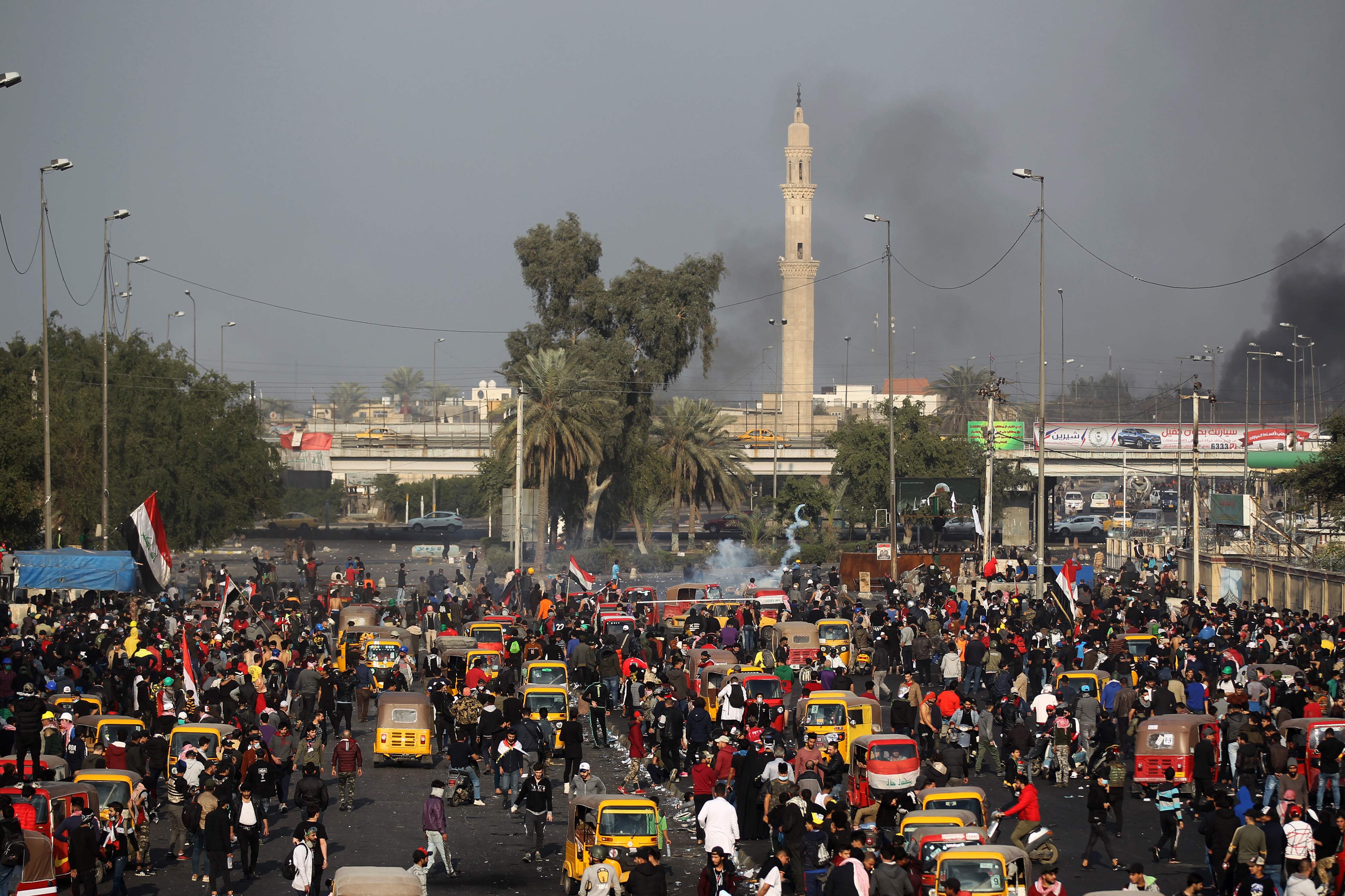 Militer Irak menembakkan gas air mata ke arah demonstran di Alun-Alun Tahrir, Baghdad.