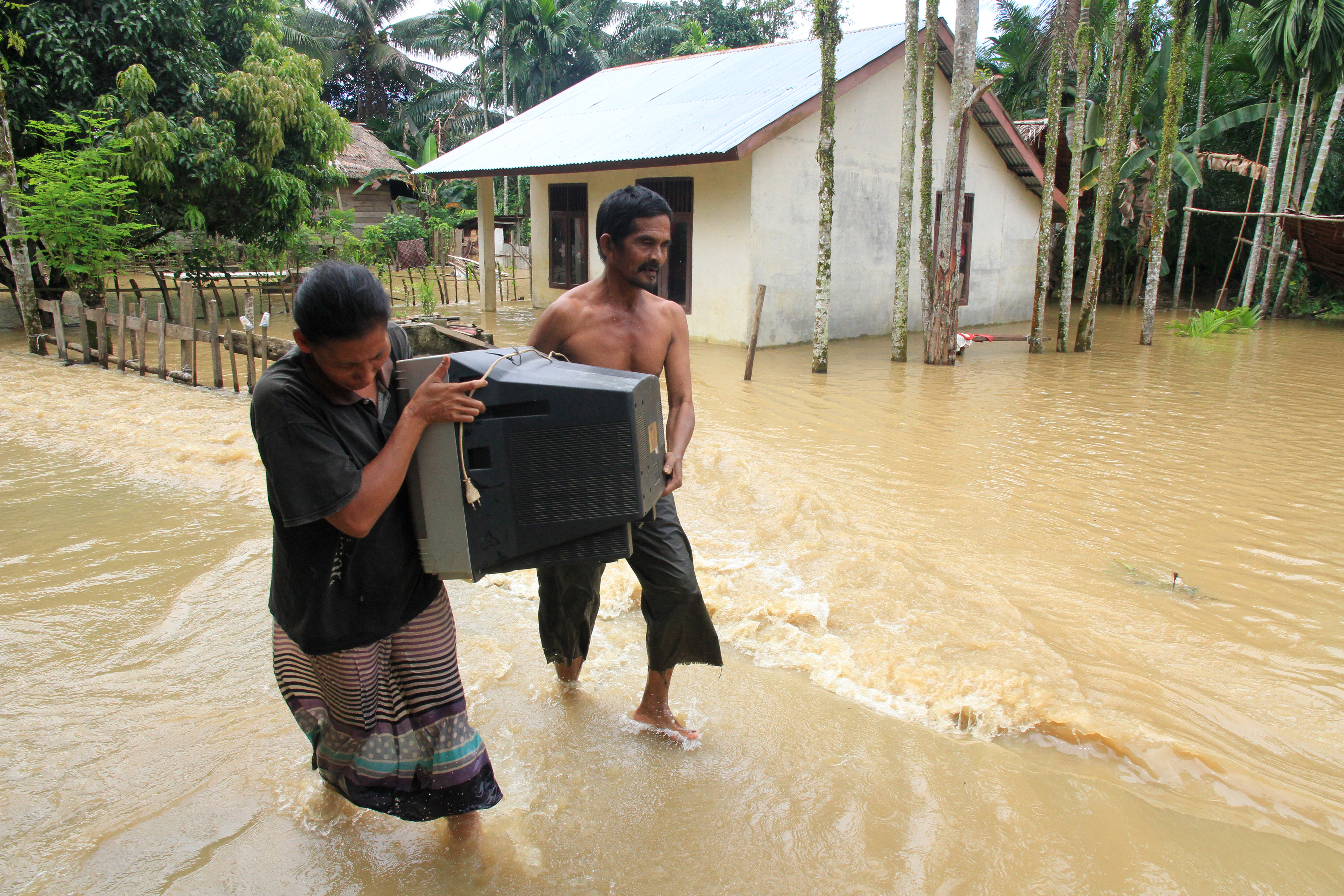 Warga memindahkan barang berharga dari genangan banjir. Saat ini ada enam kecamatan terendam banjir di Aceh Selatan.