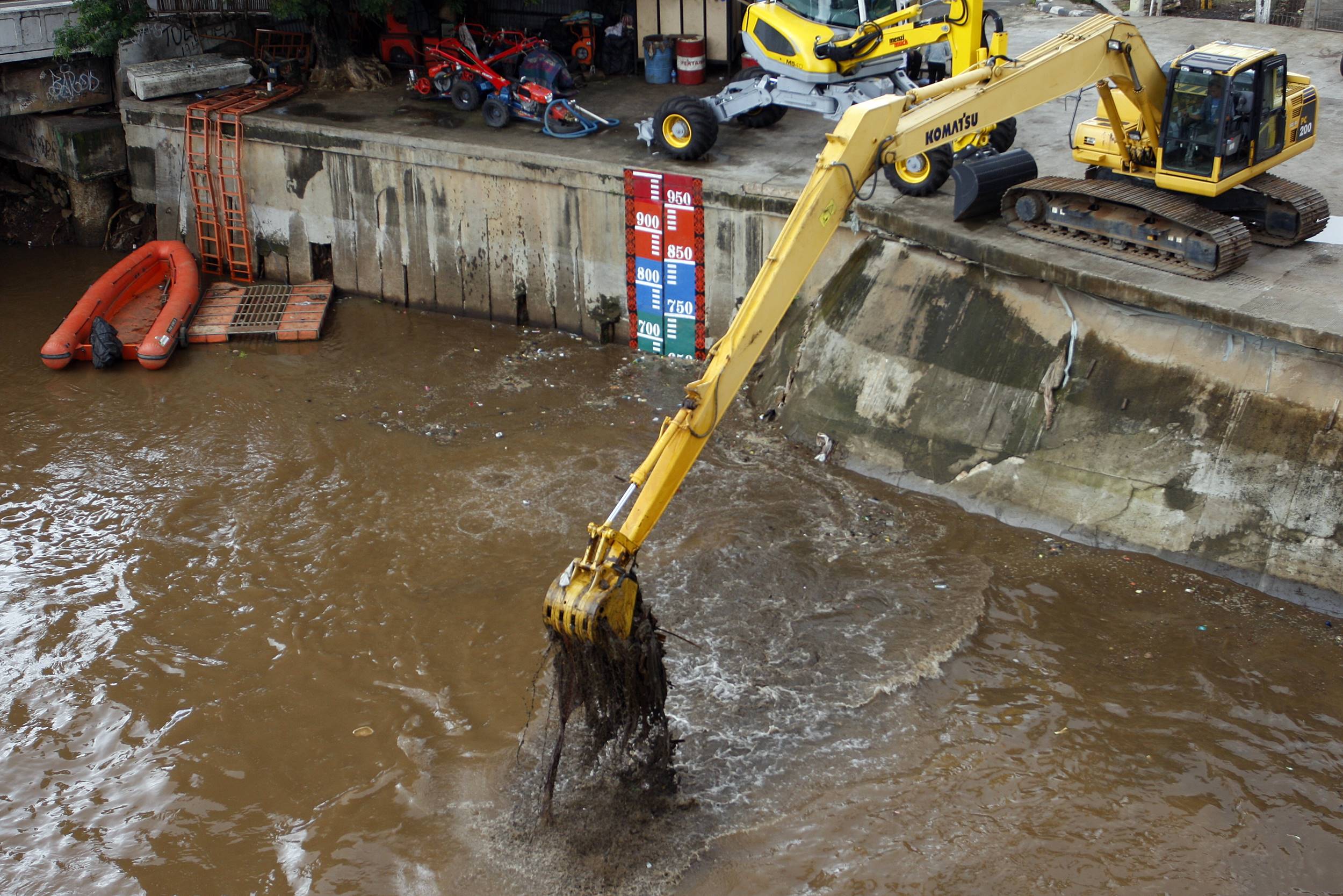 Pekerja mengoperasikan alat berat untuk mengeruk sampah di Pintu Air Manggarai, Jakarta, Kamis (3/3).