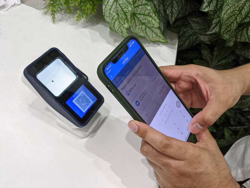 Nasabah menggunakan aplikasi Dana untuk me-scan QRIS.