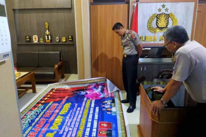 Polisi menyita 'banner' Mr Dony Pedro King of The King atau Indonesia Mercusuar Dunia (IMD). 