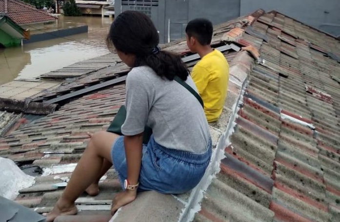 Warga menunggu di atap rumah untuk dievakuasi