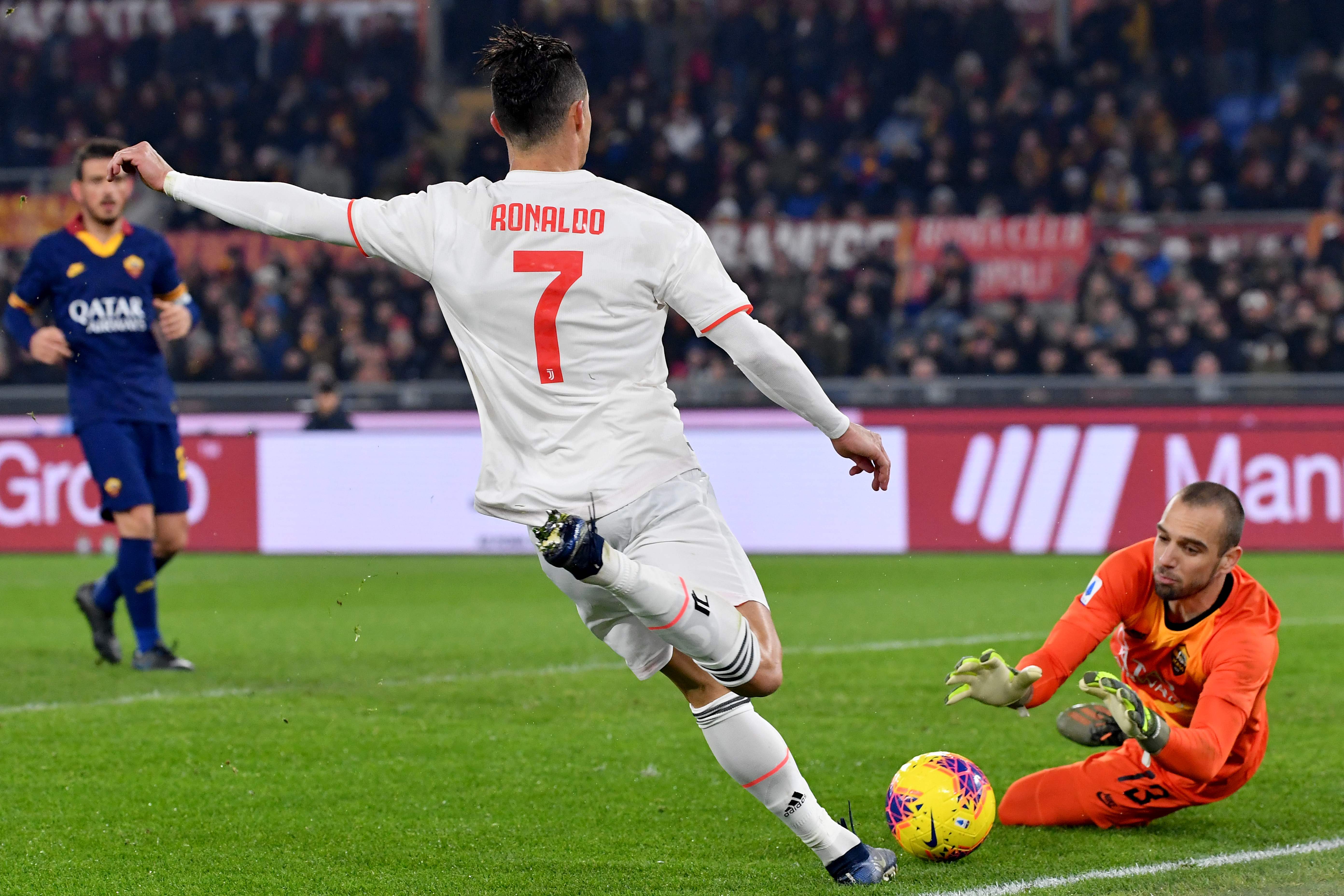   Penjaga gawang AS Roma, Pau Lopez (kanan), berusaha menyelamatkan gol dari tendangan penyerang Juventus Cristiano Ronaldo.