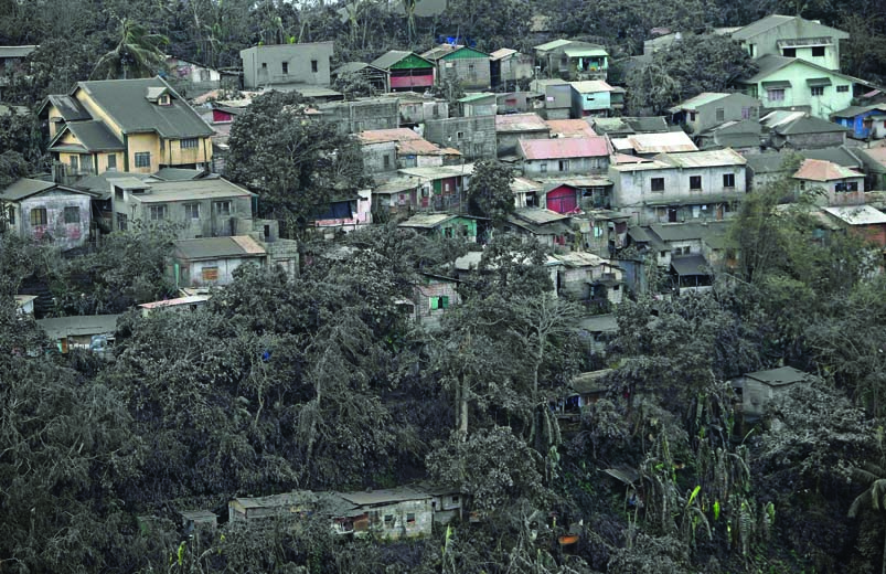 Rumah-rumah dan pepohonan terselimuti abu vulkanis letusan Gunung Taal di Tagaytay City, Filipina, kemarin. 