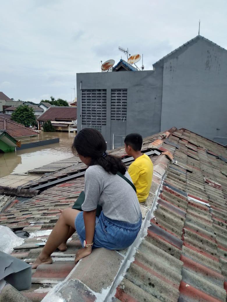 warga menunggu di atap rumah untuk dievakuasi