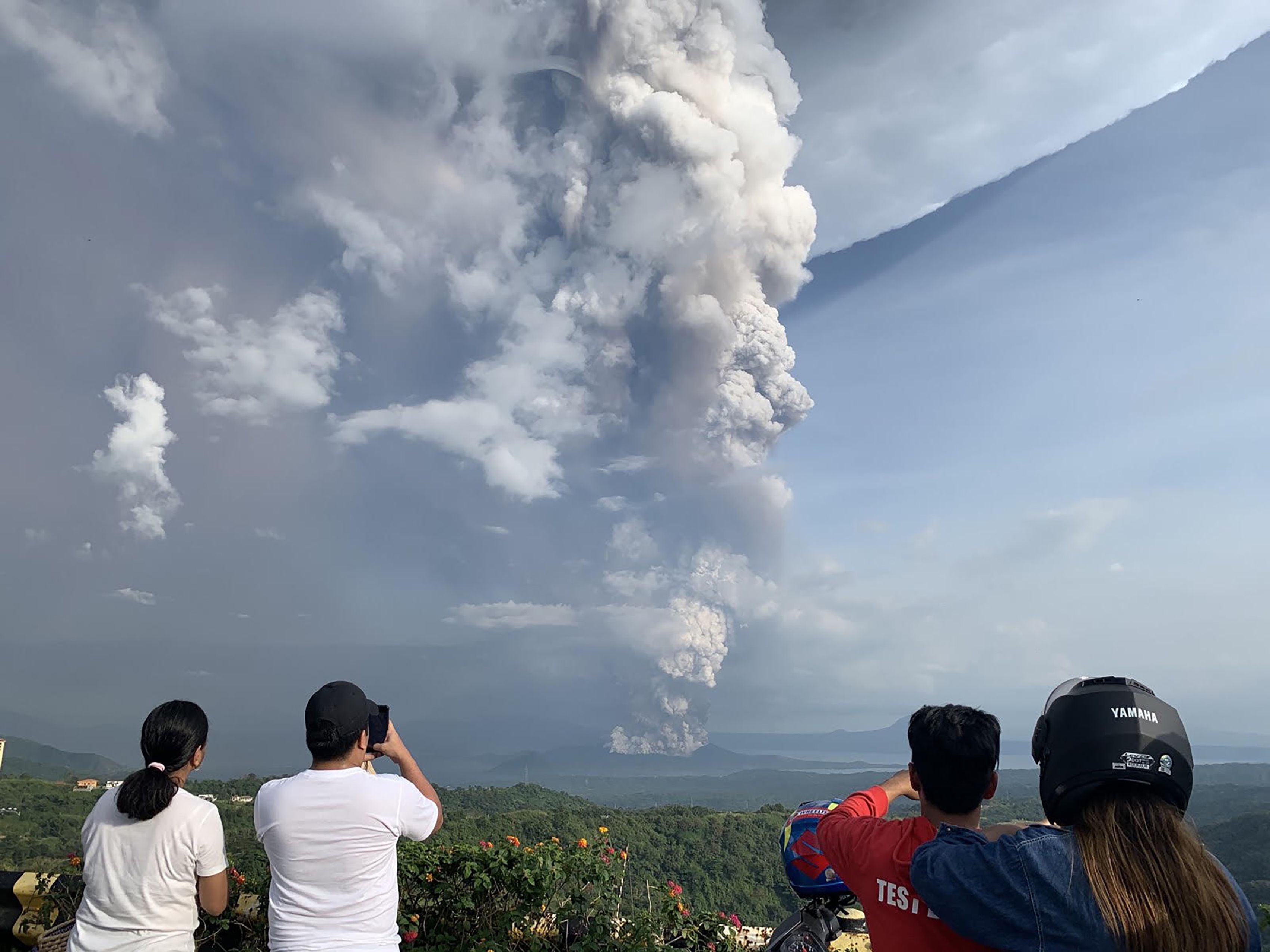 Warga mengambil gambar Gunung Taal yang memuntahkan abu.