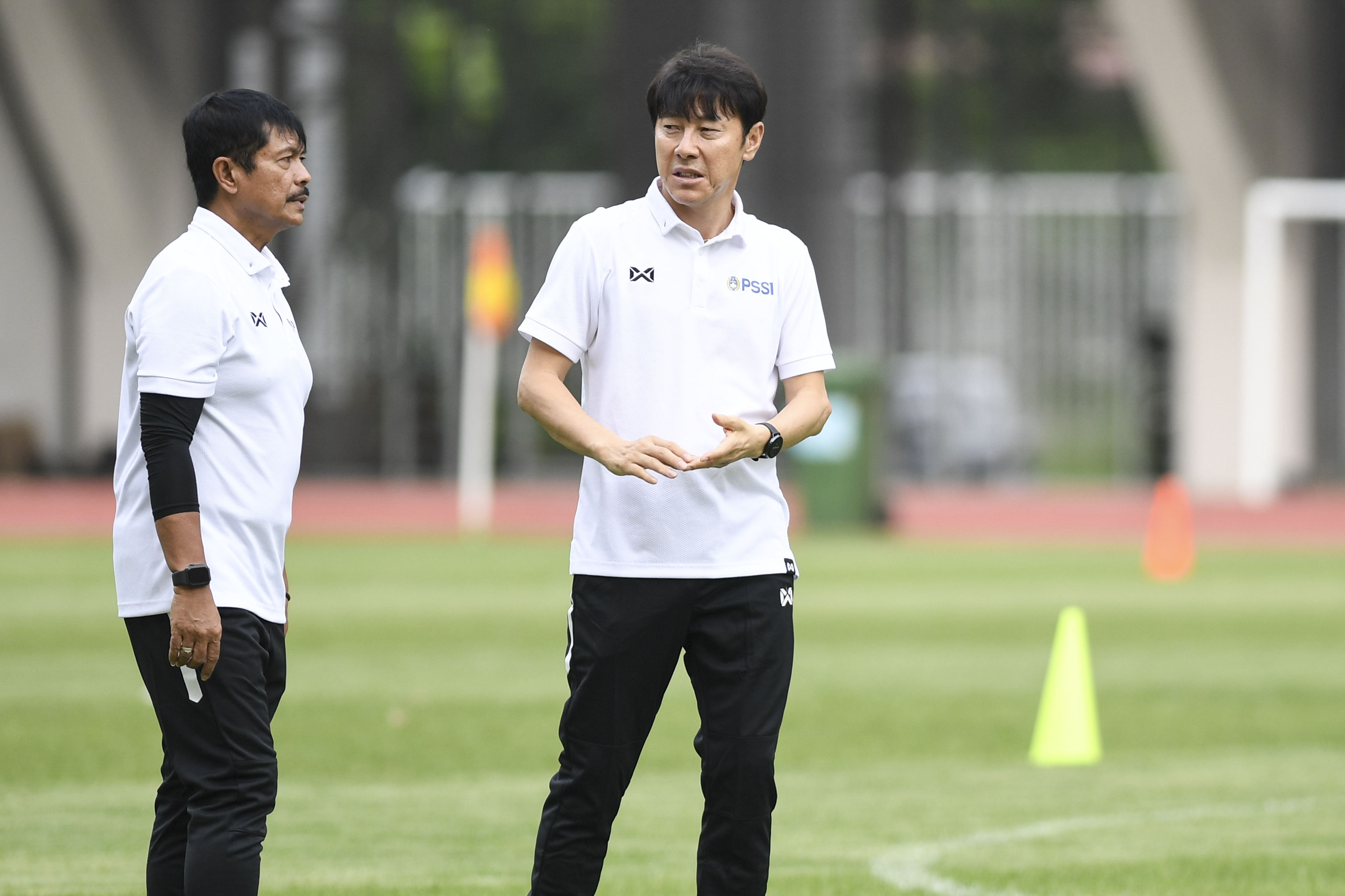 Pelatih Timnas Indonesia Shin Tae-yong (kanan) berbincang dengan asisten pelatih Indra Sjafri