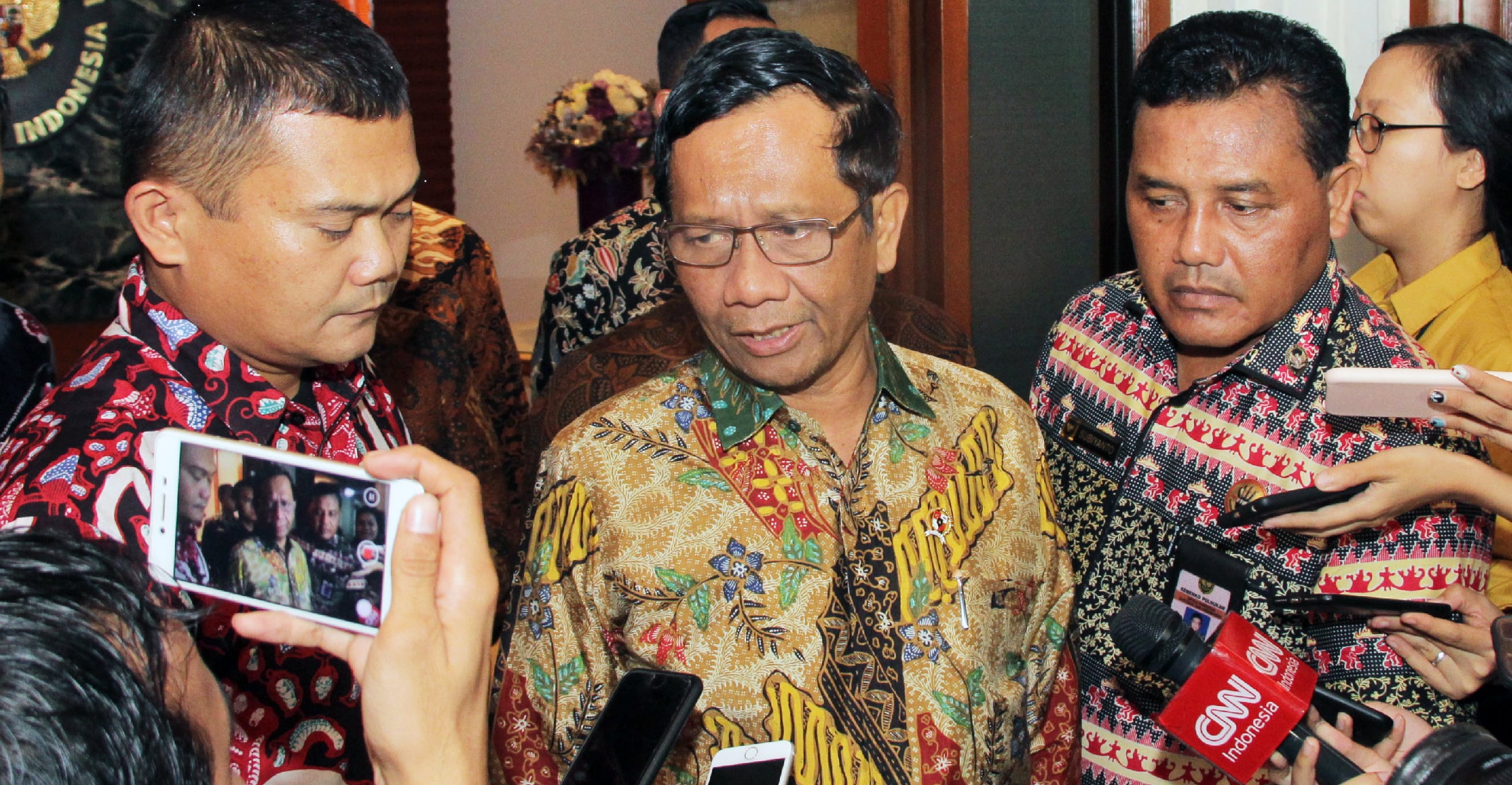 Menteri Koordinator Politik Hukum dan Keamanan (Menko Polhukam) Mahfud MD (tengah) memberikan keterangan kepada awak media. 