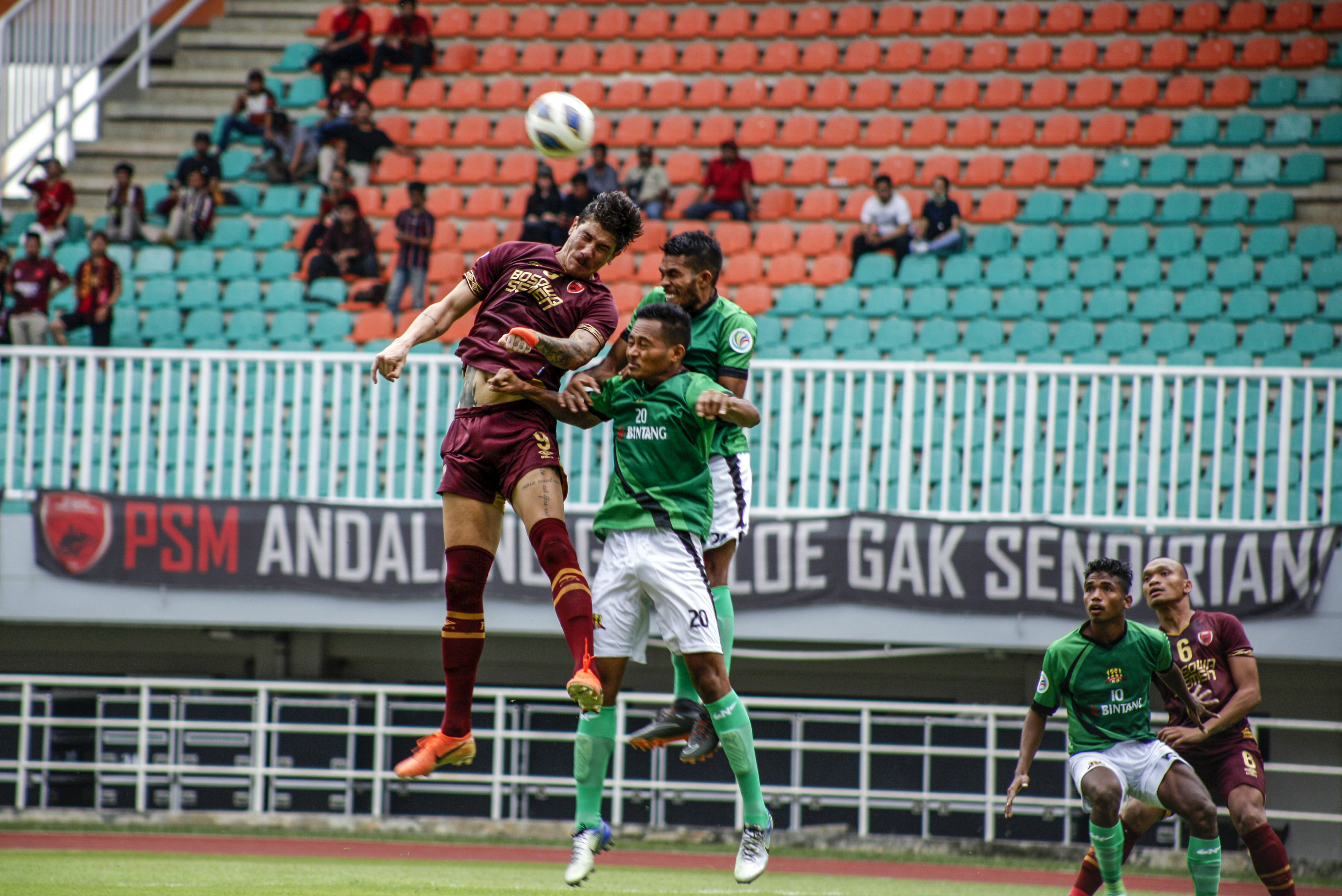 Pemain PSM Makassar Giancarlo Rodrigues (kiri) berebut bola di udara dengan dua orang pemain Lalenok United. 