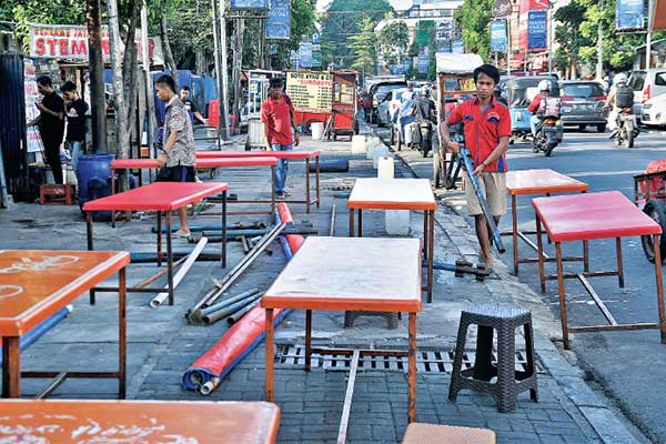 Para pedagang kaki lima (PKL) tengah mempersiapkan lapaknya di trotoar Jalan Sabang, Menteng, Jakarta Pusat, kemarin.