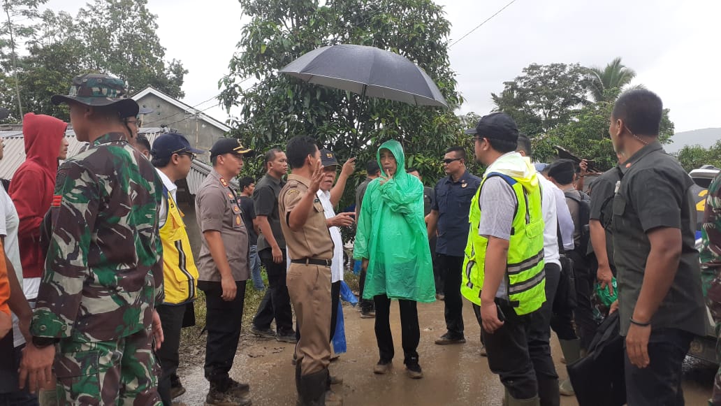 Presiden Joko Widodo mengenajan jas hujan plastik saat berkunjung meninjau korban lonsor di Bogor
