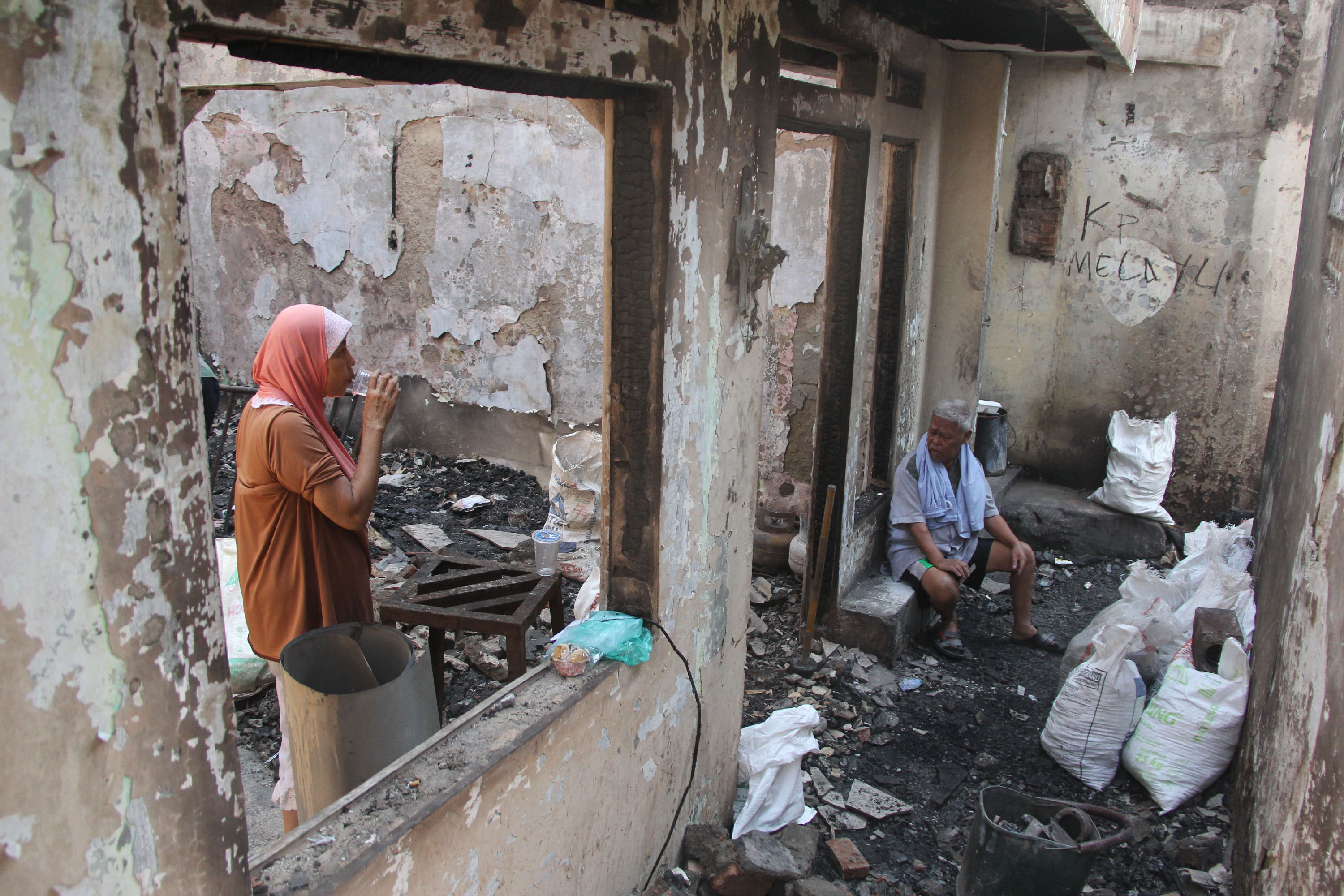 Warga membersihkan sisa barang dalam rumah yang terbakar di RW 02 Bidara Cina, Jatinegara, Jakarta Timur, pada tahun lalu.