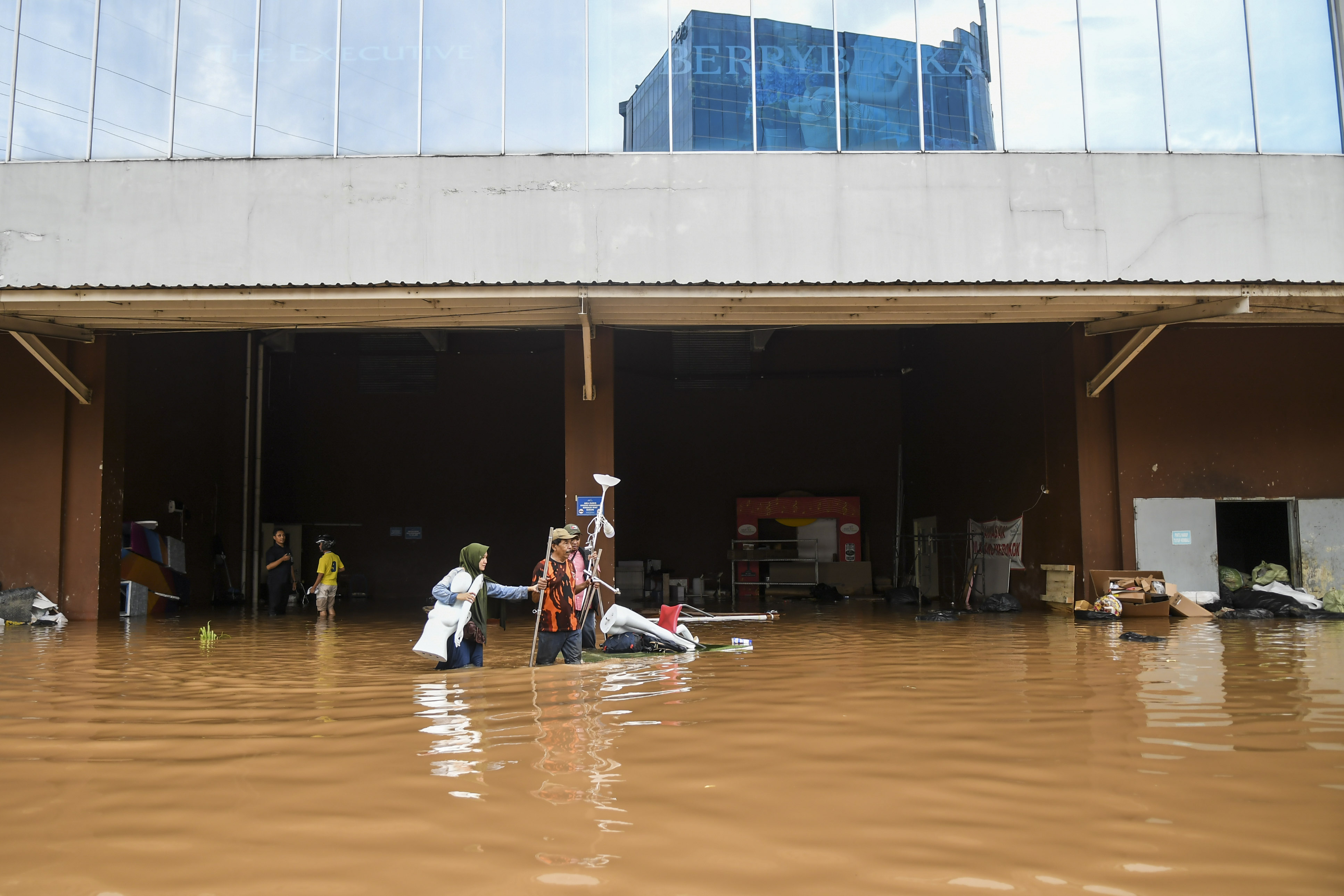  Pedagang mengevakuasi barang dagangan yang terendam banjir di Mal Cipinang Indah, Jakarta Timur, Rabu (1/1/2020).