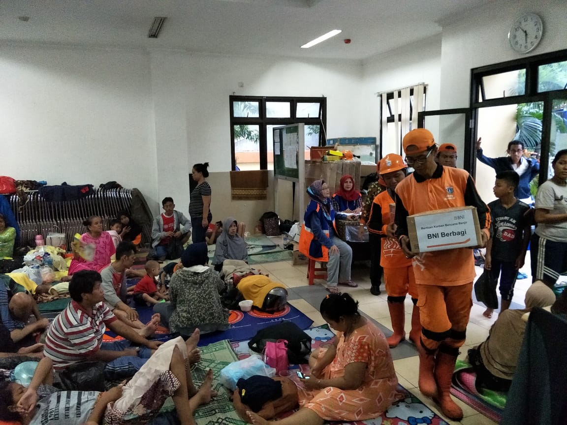 Petugas sedang membagikan bantuan dari BNI pada korban bencana banjir di Jakarta, Rabu, 1 Januari 2020.