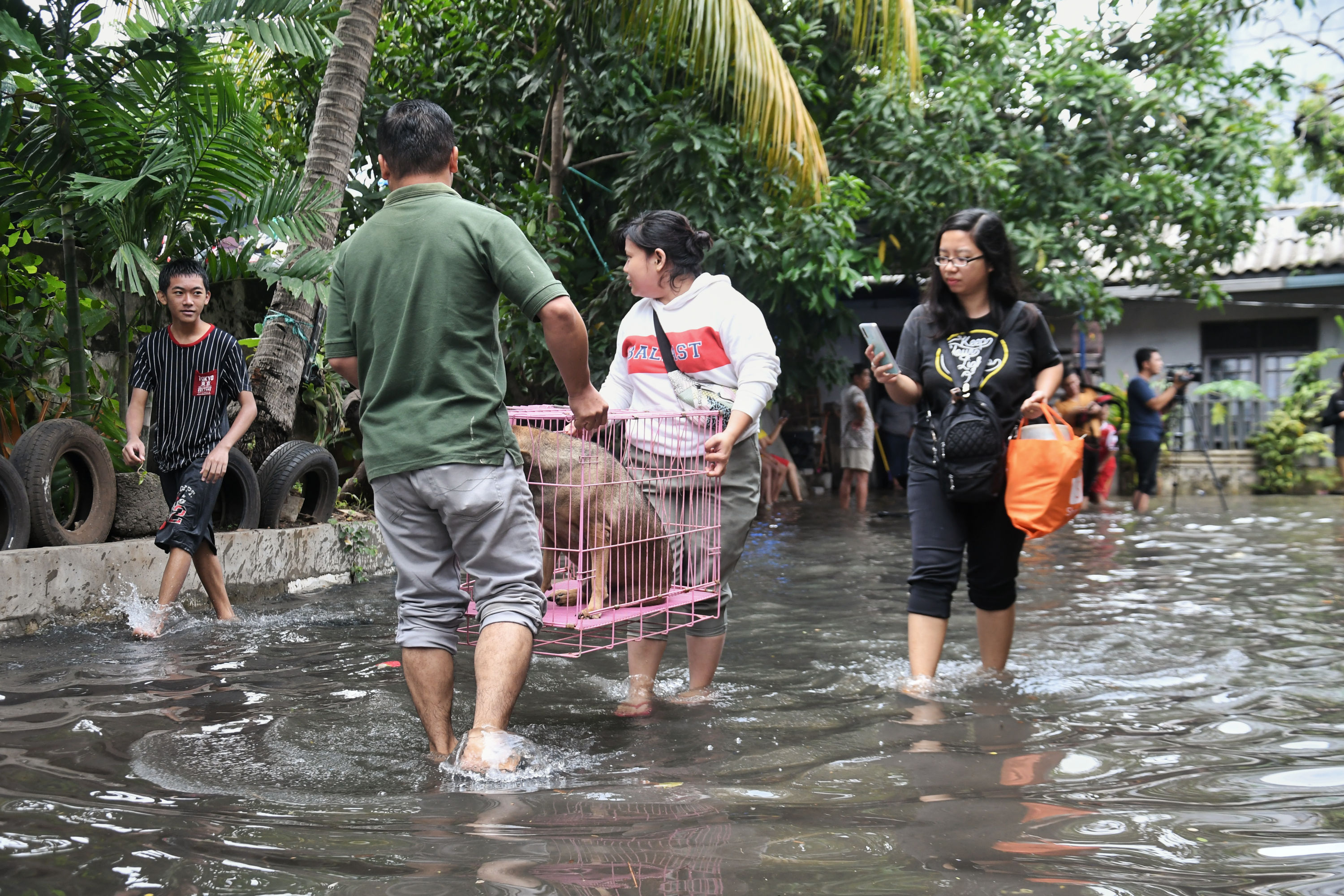Warga membersihkan lingkungan rumahnya yang terendam banjir di kawasan Kebon Jeruk, Jakarta.