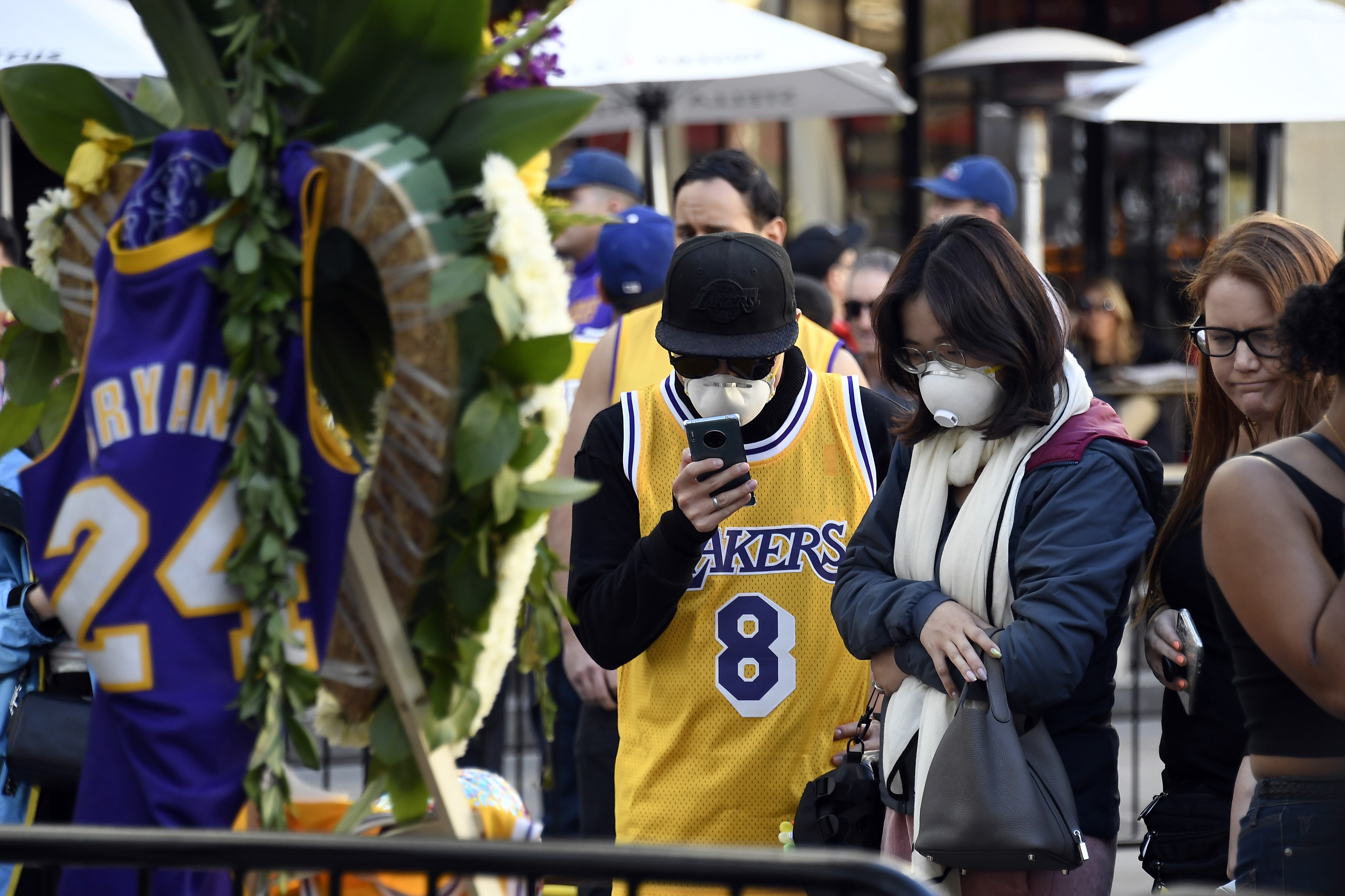  Para fans yang mengenakan jersey nomor 8 dan 24 saat memberi penghormatan kepada mendiang Kobe Bryant dan putrinya Gianna, 13.