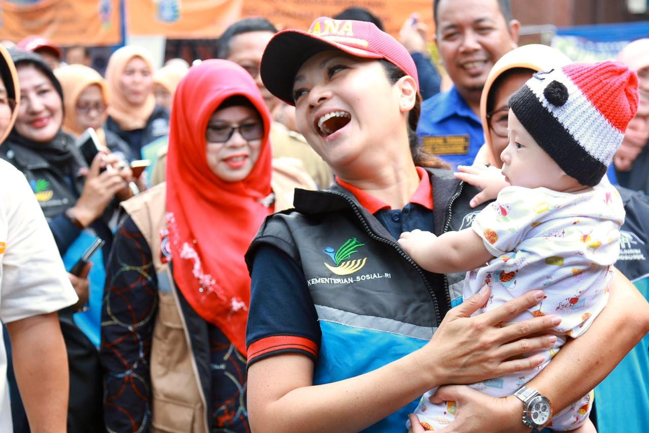 Ibu Grace Batubara menggendong bayi terdampak banjir di Cengkareng.