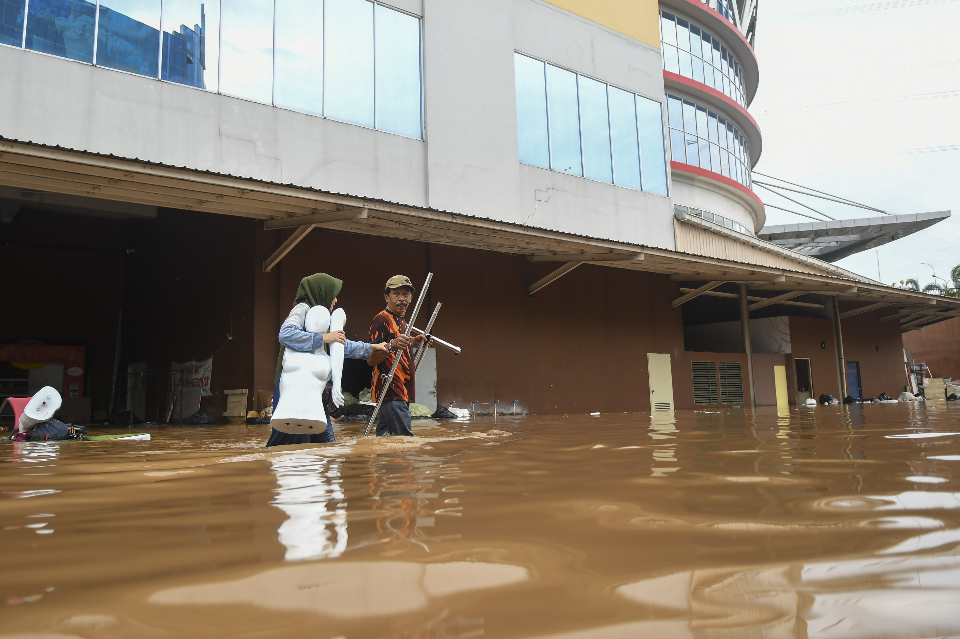 Pedagang mengevakuasi barang dagangannya yang terendam banjir di Mal Cipinang Indah, Jakarta Timur.