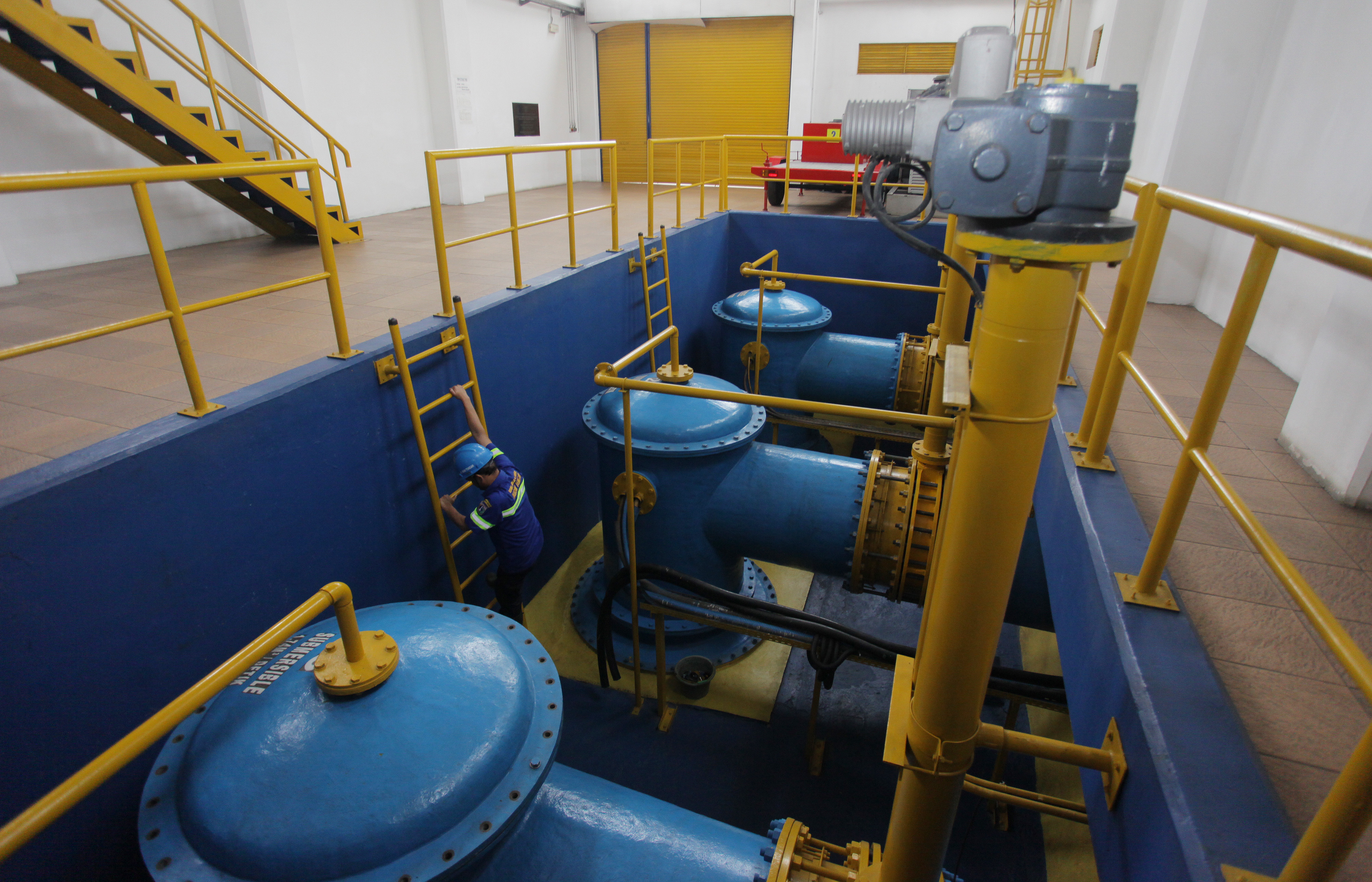 Petugas Dinas Sumber Daya Air memeriksa pompa air di rumah Pompa Waduk Setia Budi Timur, Jakarta