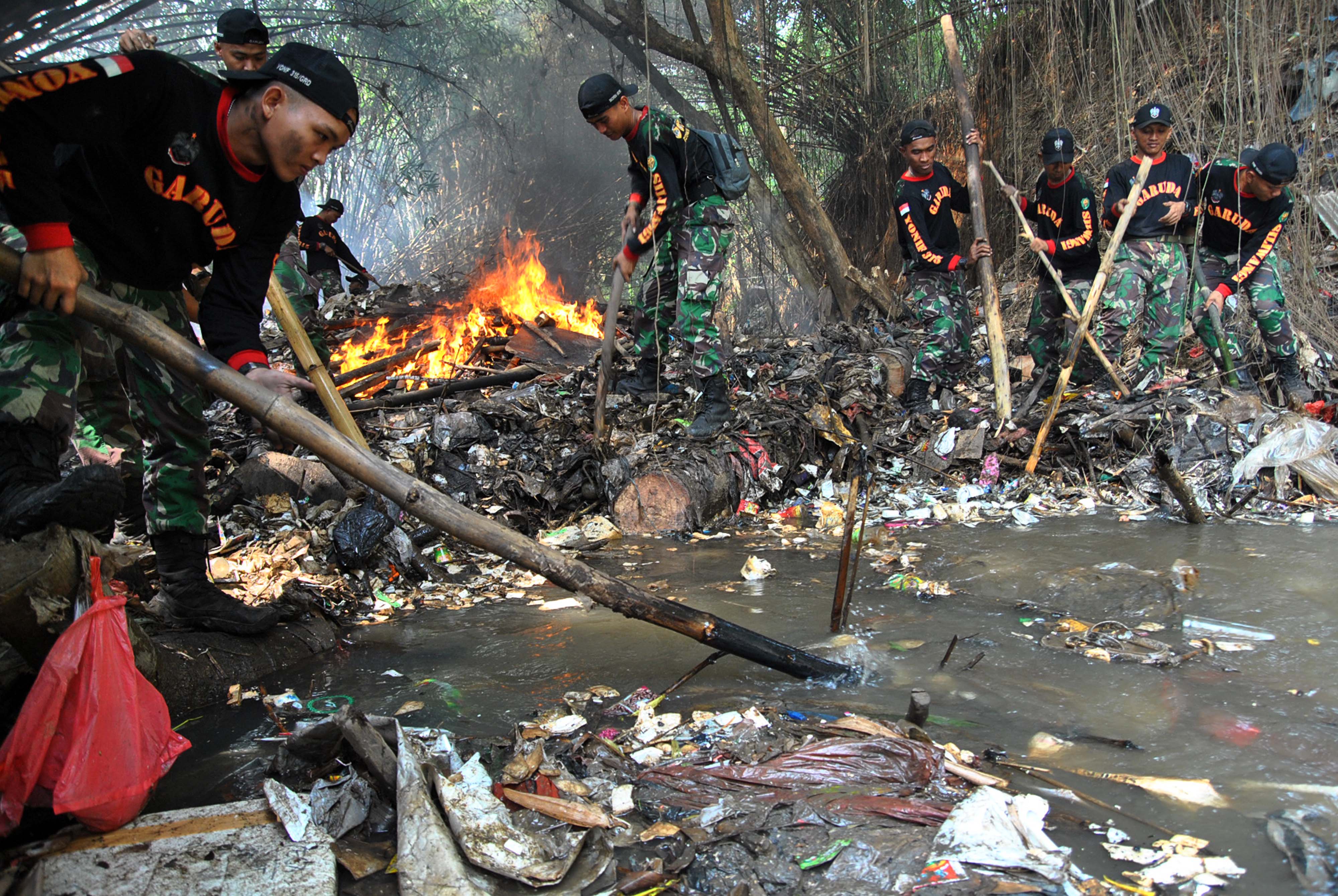 Sejumlah anggota Yonif 315/Garuda Bogor membersihkan sampah yang menghambat aliran air Cisadane, Kali Baru Barat, Cilebut, Kabupaten Bogor