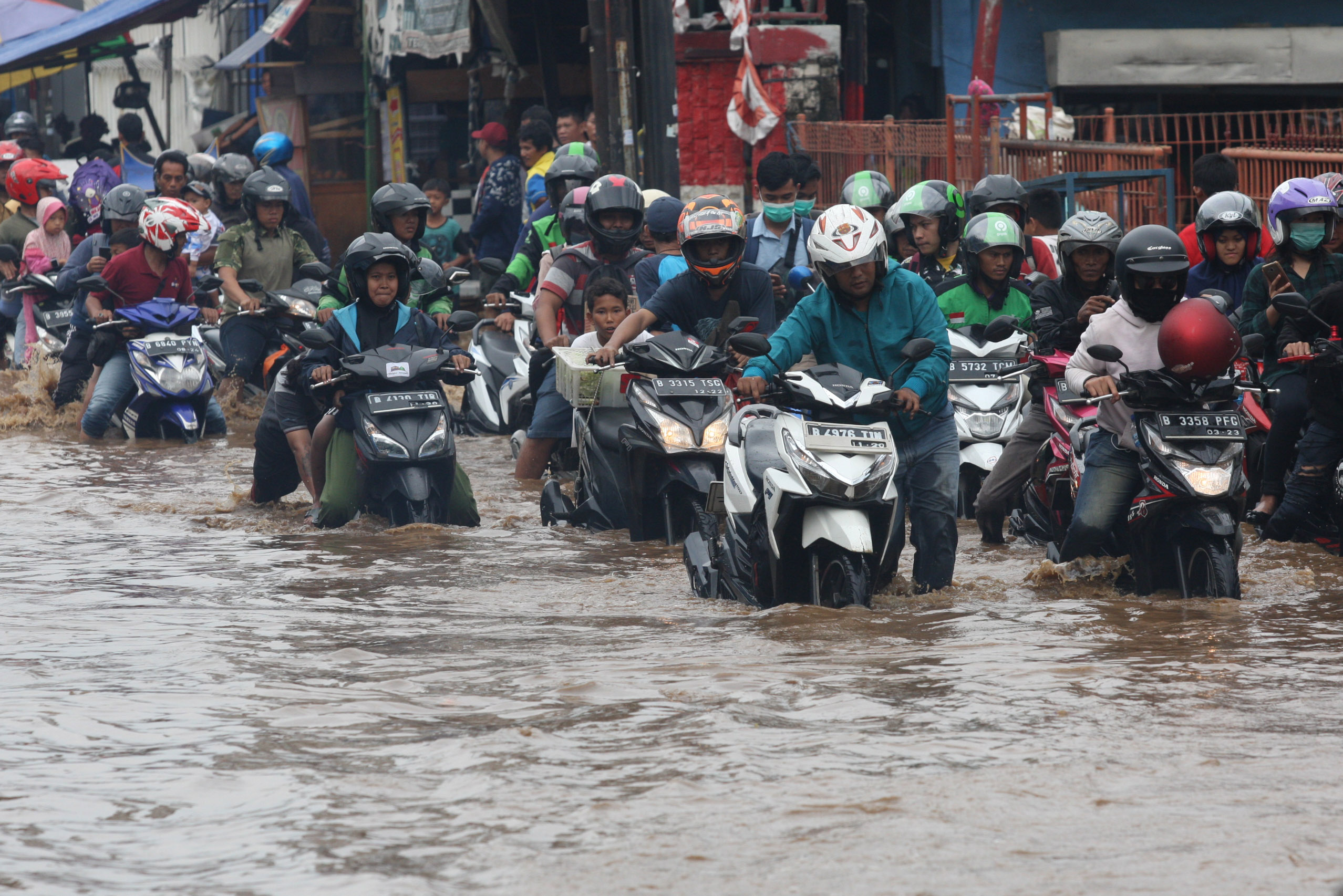 Puluhan motor mogok setelah menerjang banjir di jalan Raya Bogor, Kramat Jati, Jakarta (1/1).