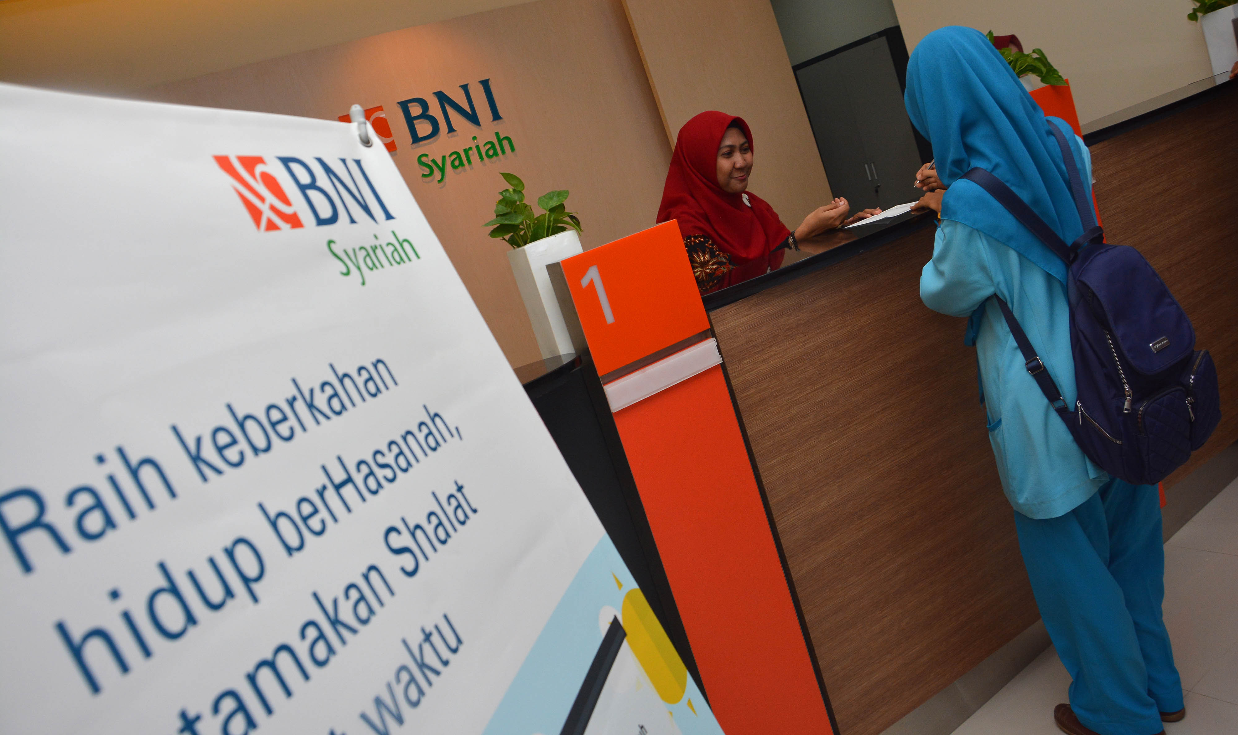 Ilustrasi: Petugas teller bank melayanai nasabah usai peresmian kantor cabang pembantu (KCP) BNI Syariah Jombang