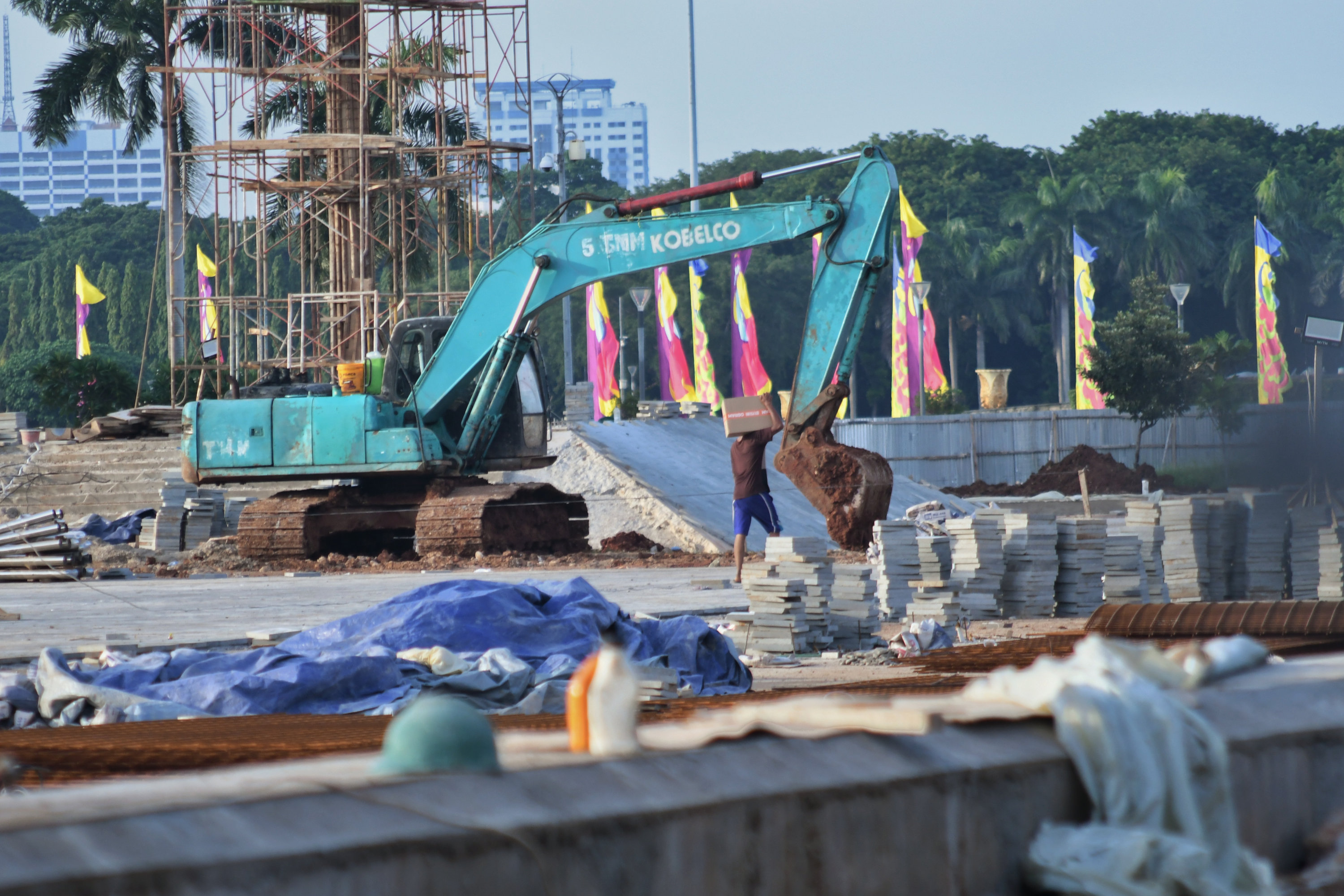 Aktivitas para pekerja usai diberhentikannya proyek revitalisasi sisi selatan Monumen Nasional, Jakarta.