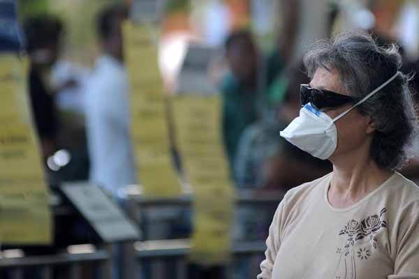 Seorang penumpang pesawat mengenakan masker.