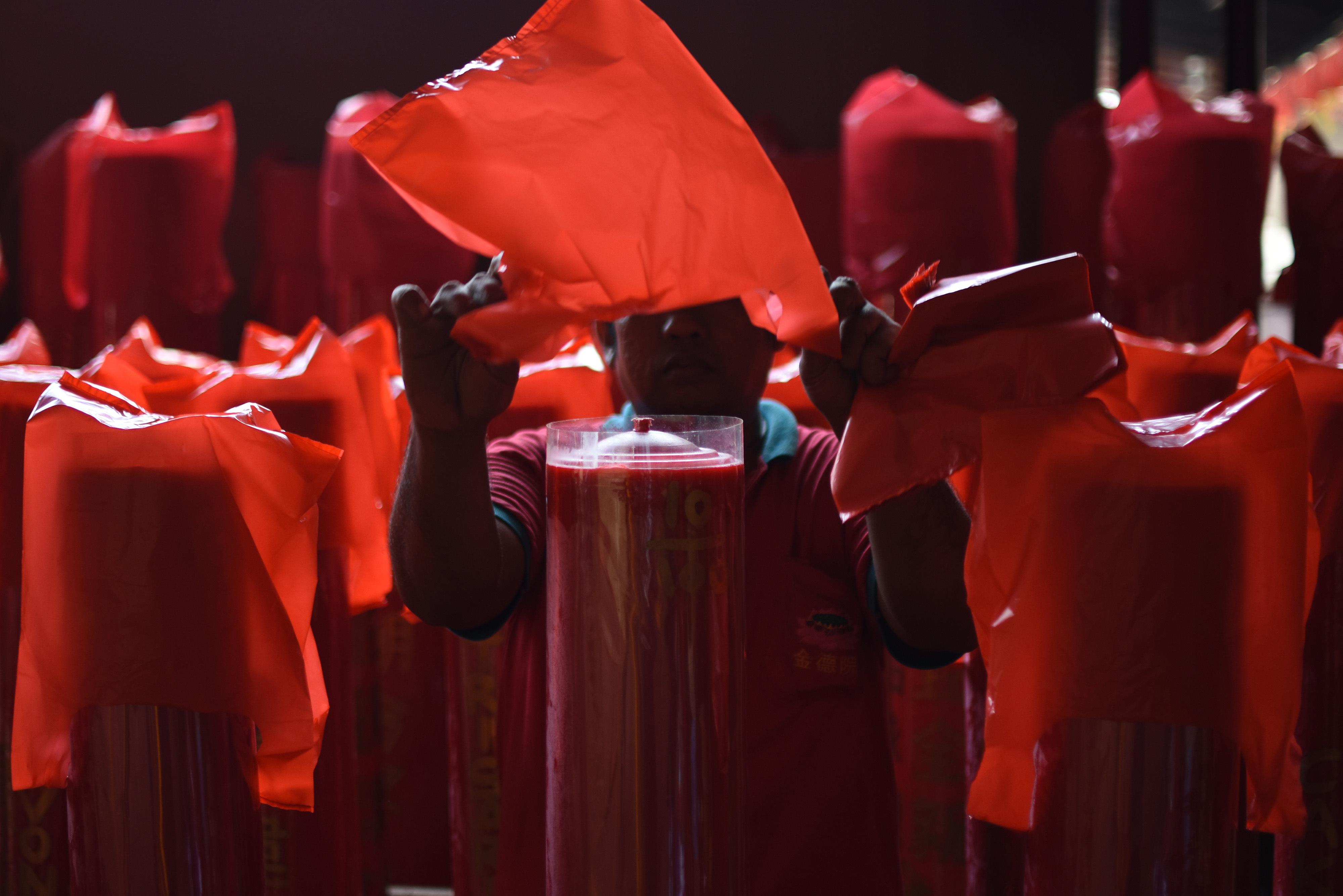 Pekerja menutup lilin yang telah dipesan jemaat di Vihara Dharma Bhakti, Petak Sembilan, Jakarta.