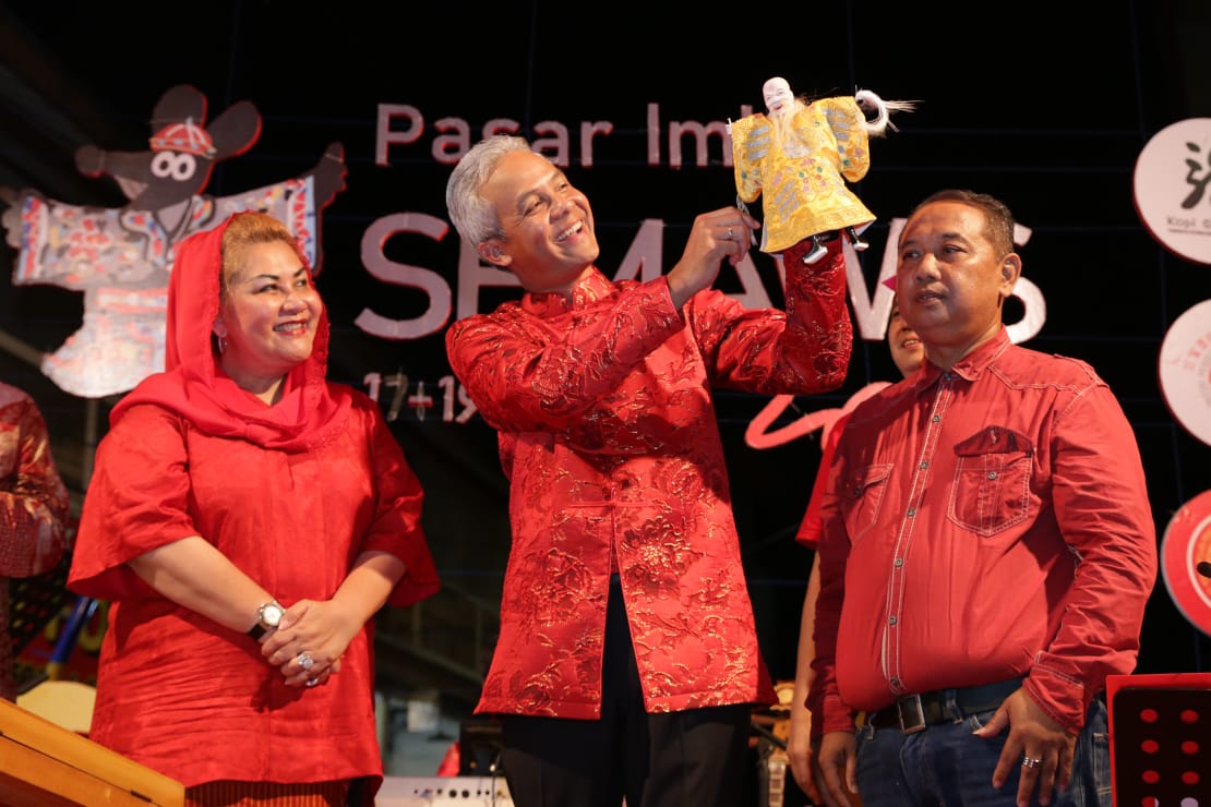 Gubernur Jawa Tengah Ganjar Pranowo mengeluarkan souvernir wayang potehi yang dia terima di atas panggung Pasar Semawis, Jumat (17/1/2020).