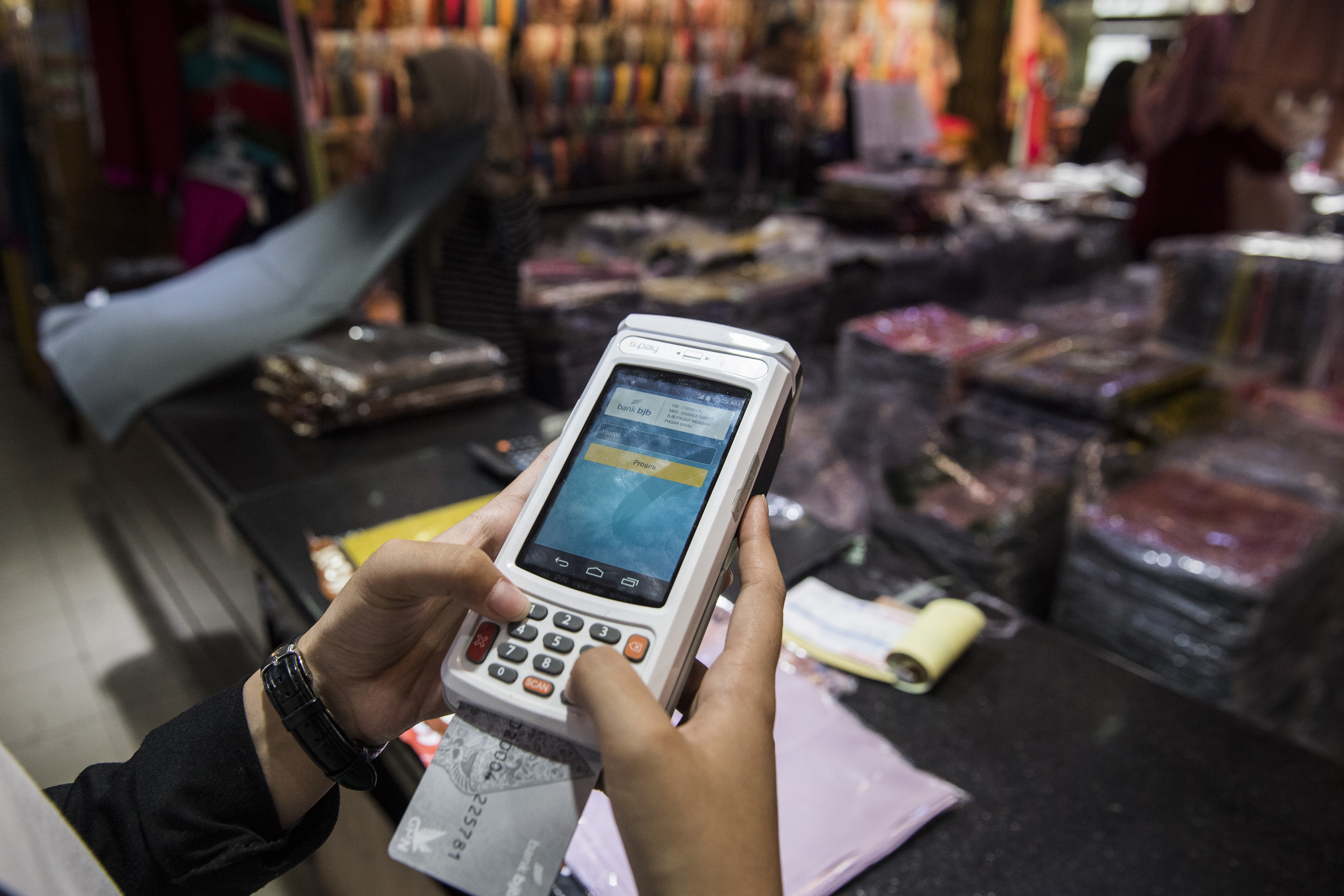Pembeli melakukan transaksi pembayaran digital dengan mesin EDC berbasis android di Pasar Baru, Bandung, Jawa Barat.