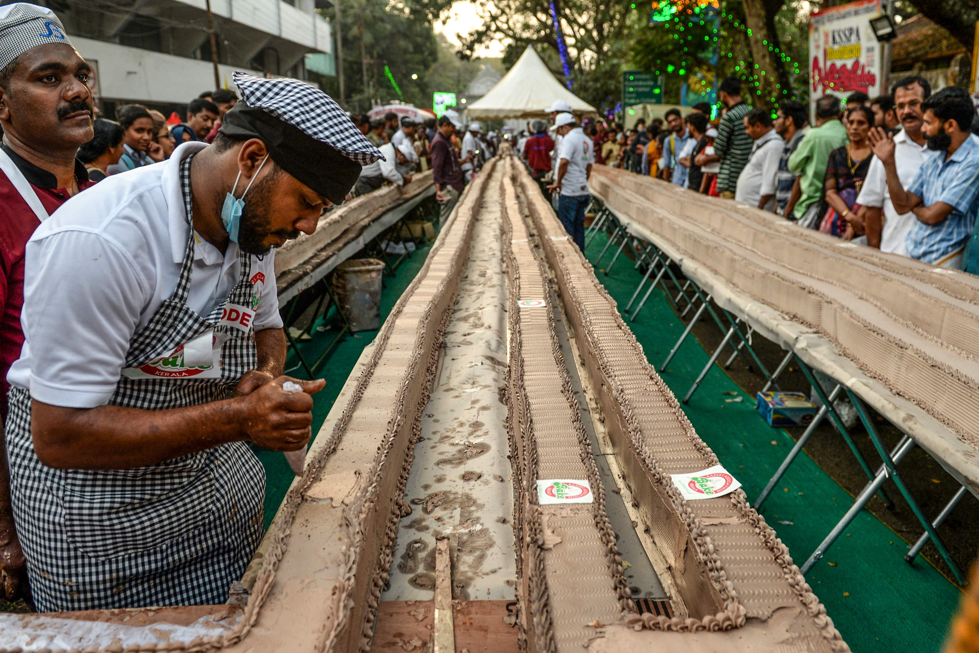 Seorang koki memberi hiasan cokelat kepada kue sepanjang 6,5 meter di Kota Thrissur, Negara Bagian Kerala, India.