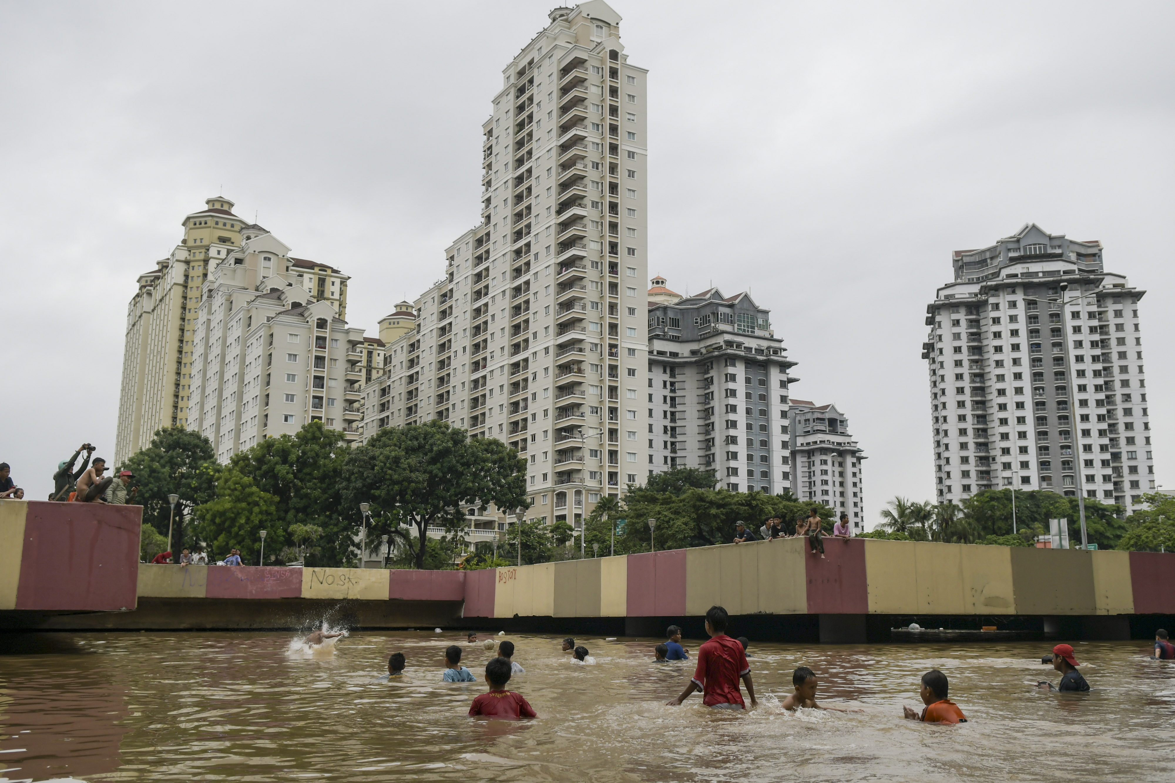  Sejumlah anak bermain saat banjir menutup terowongan di jalan Kota Baru Bandar Kemayoran, Jakarta.