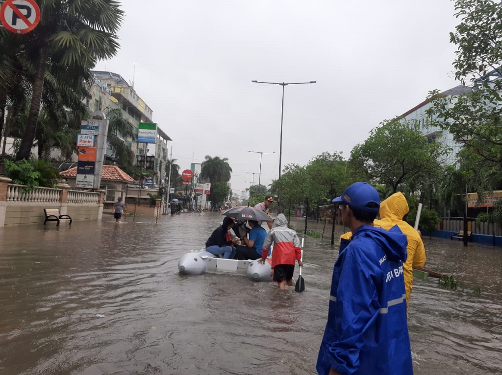 Jajaran Polsek Tanjung Duren bersama PPSU Kelurahan Tanjung Duren Selatan mengevakuasi warga menggunakan perahu karet. 
