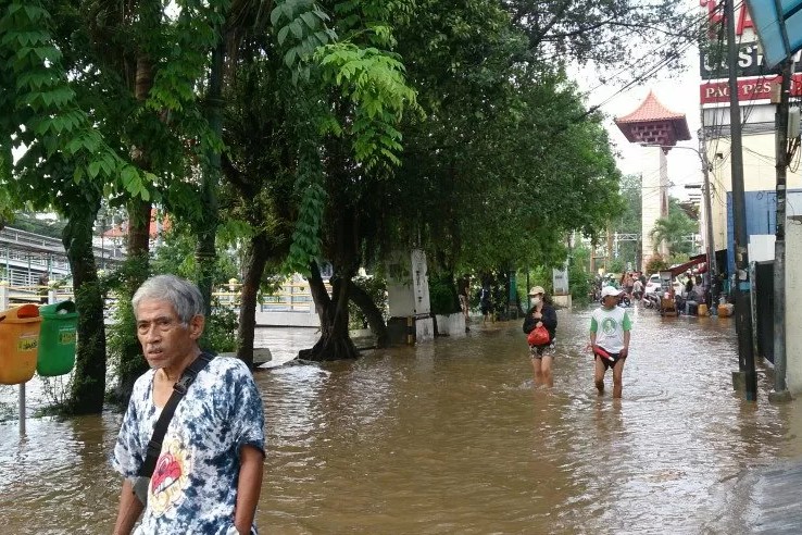 Jalan Pasar Baru Selatan digenangi banjir luapan Sungai Ciliwung yang meluap rata dengan jalanan, Kamis (2/1)