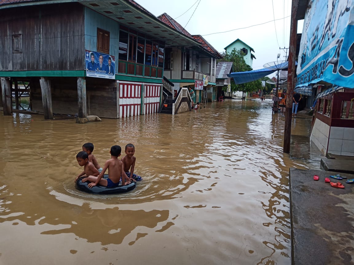 Anak-anak bermain air saat rumahnya teremdam banjir di Kabupaten Empat Lawang, Sumatera Selatan.
