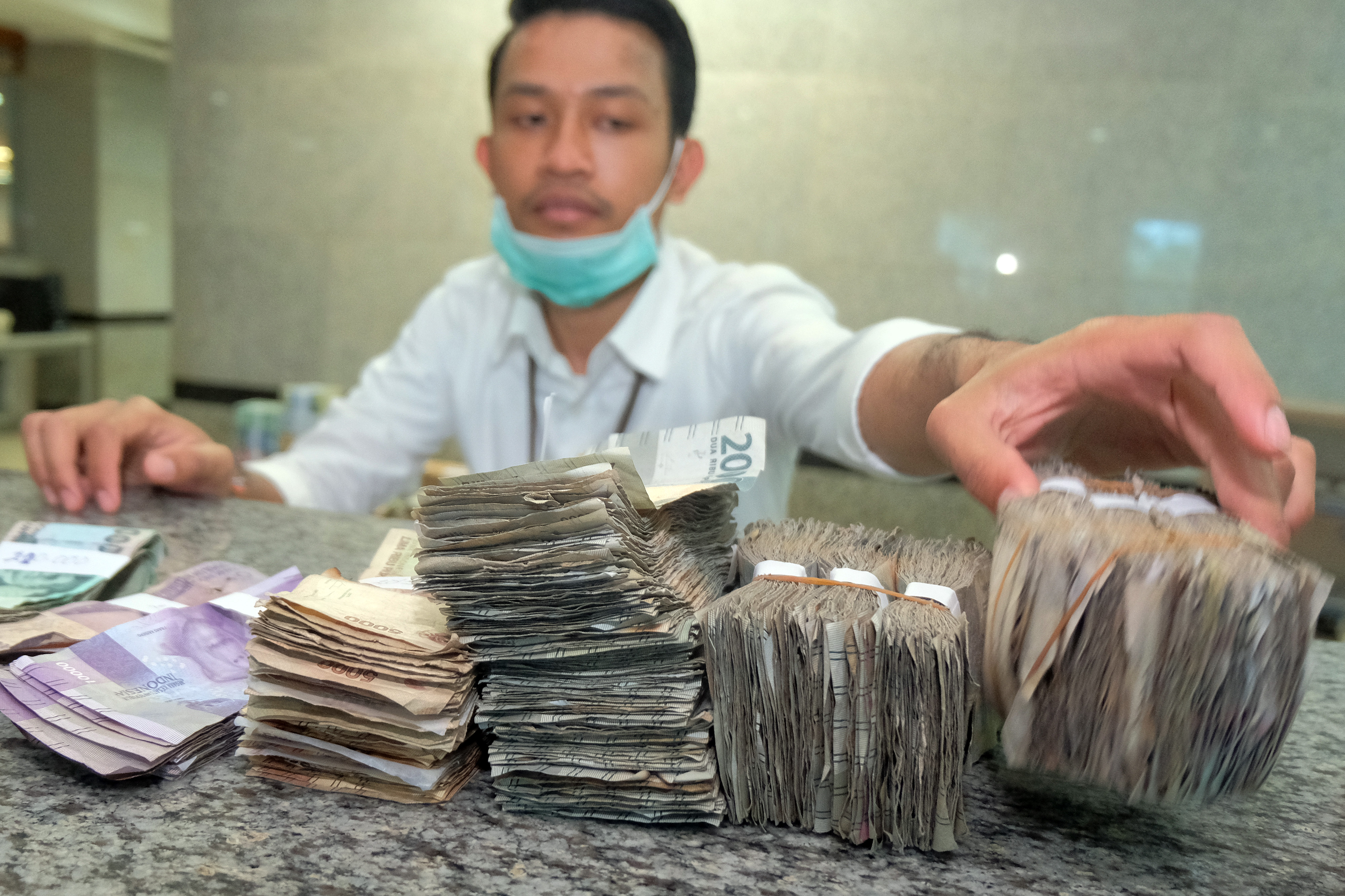 Petugas memeriksa uang lusuh yang ditukarkan warga saat peluncuran program Bali Bersih Uang Lusuh (Bali Bersiul) beberapa waktu lalu.