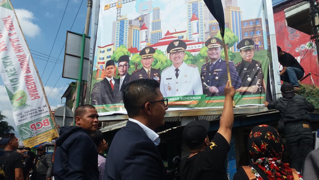 Baliho alat peraga kampanye milik Cecep Wahyudin diganti sepihak oleh Pemkab Cianjur. Pemiliknya meradang karena mereka membayar pajak iklan