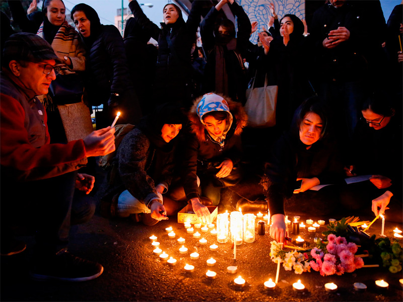 Warga Iran menyalahkan lilin untuk para korban pesawat Boeing 737 Ukraine International Airlines di depan Universitas Amirkabir, di Teheran.