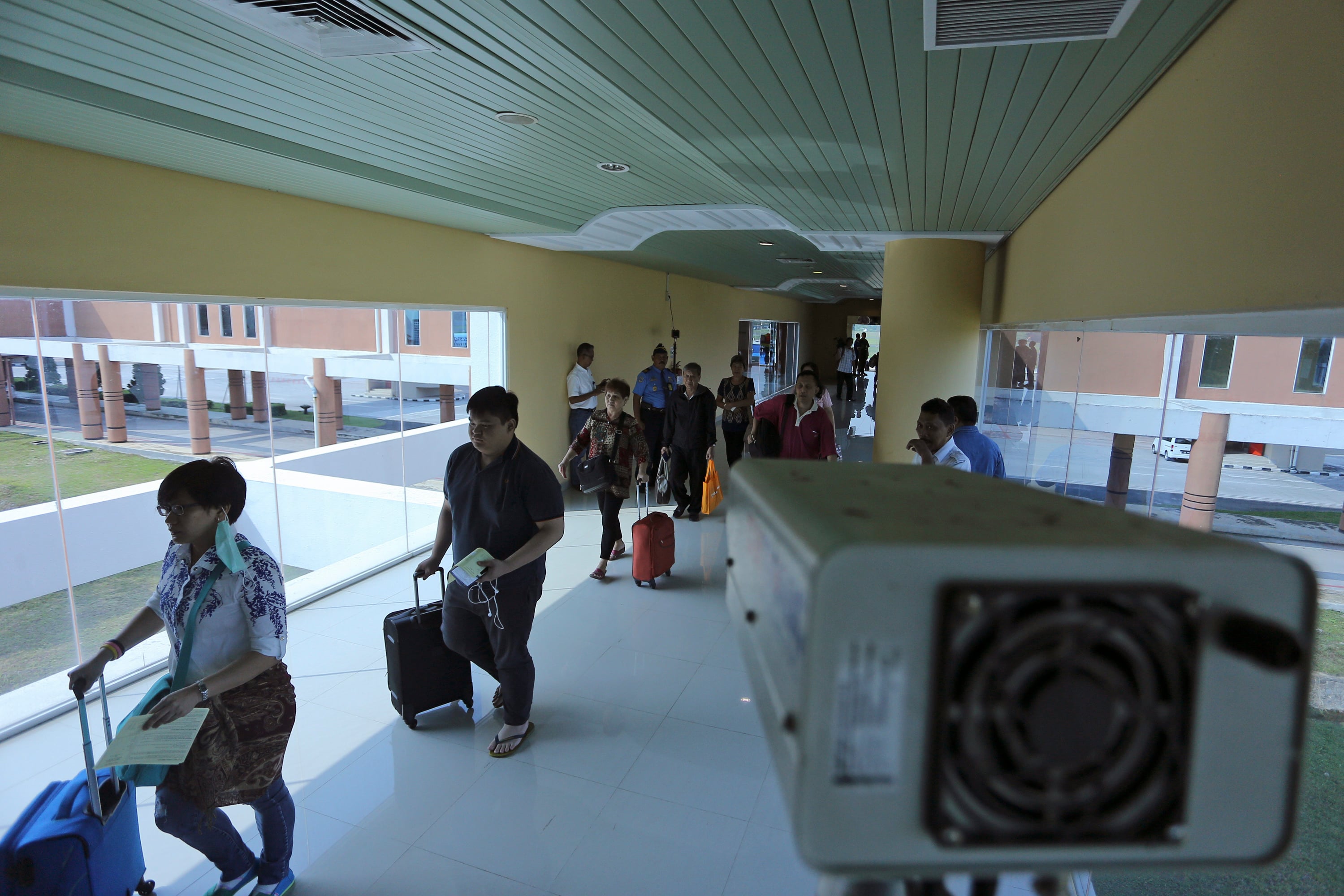 Petugas KKP melakukan pemantauan suhu tubuh penumpang pesawat menggunakan thermo infrared di terminal kedatangan internasional. 